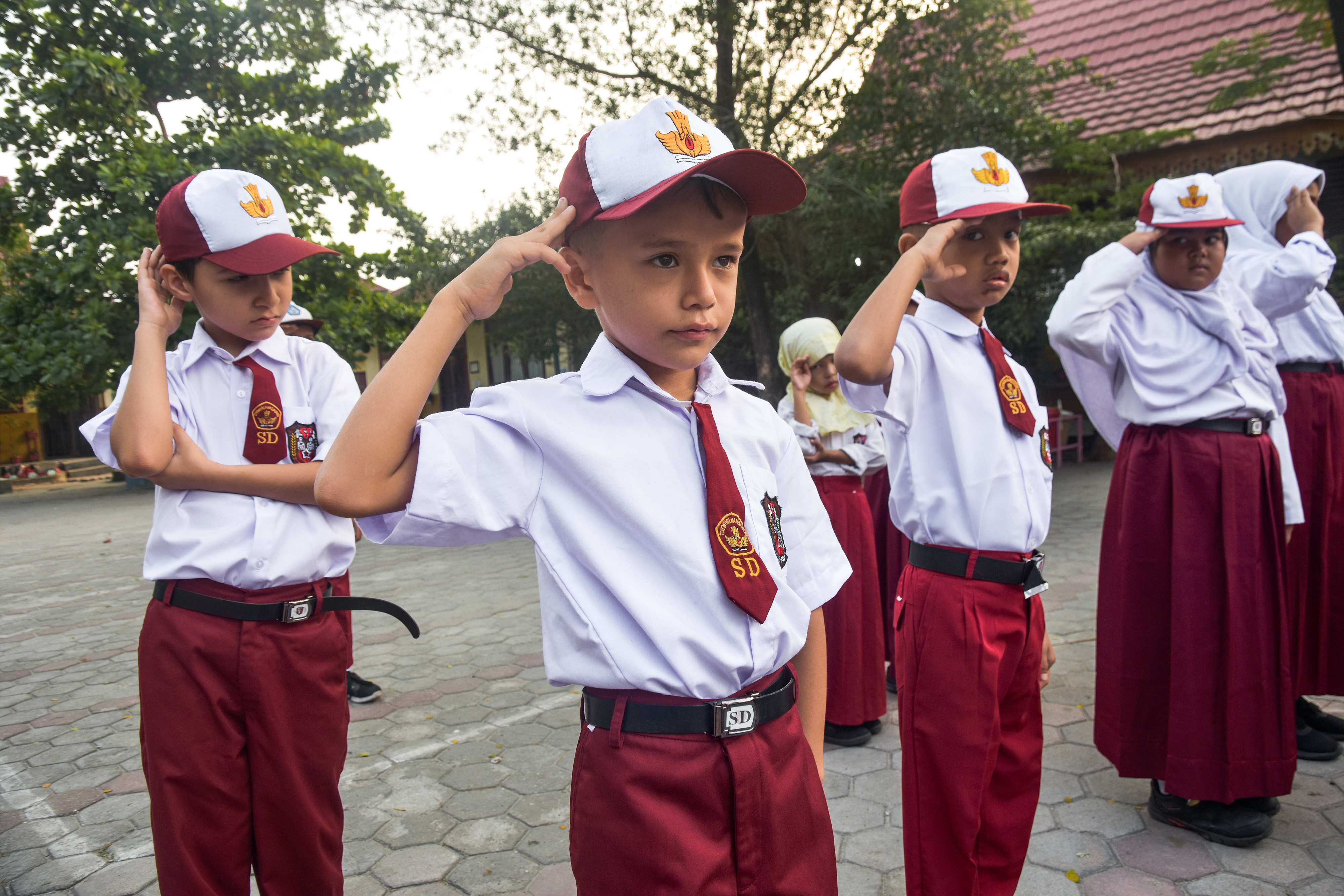 Seorang anak pencari suaka memberi hormat saat upacara bendera di SDN 159 Kota Pekanbaru, Riau.