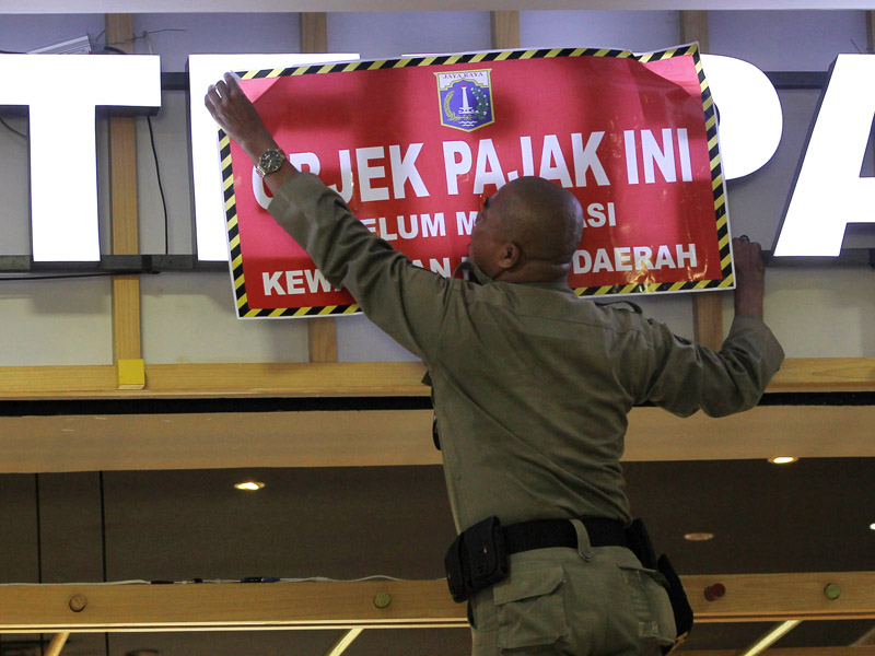 Ilustrasi--Petugas memasang plang pengunggak pajak