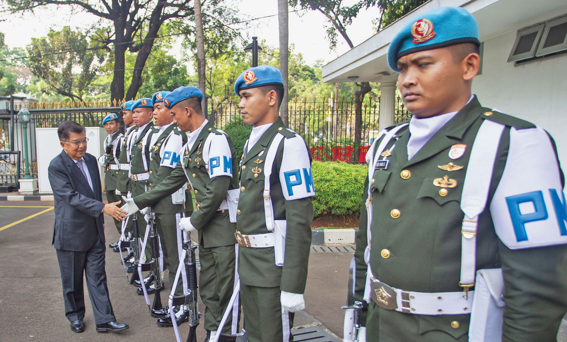 Wakil Presiden Jusuf Kalla menyalami pengawal istana Wakil Presiden dari satuan Batalyon Pengawal Protokoler Kenegaraan (Yonwalprotneg)  