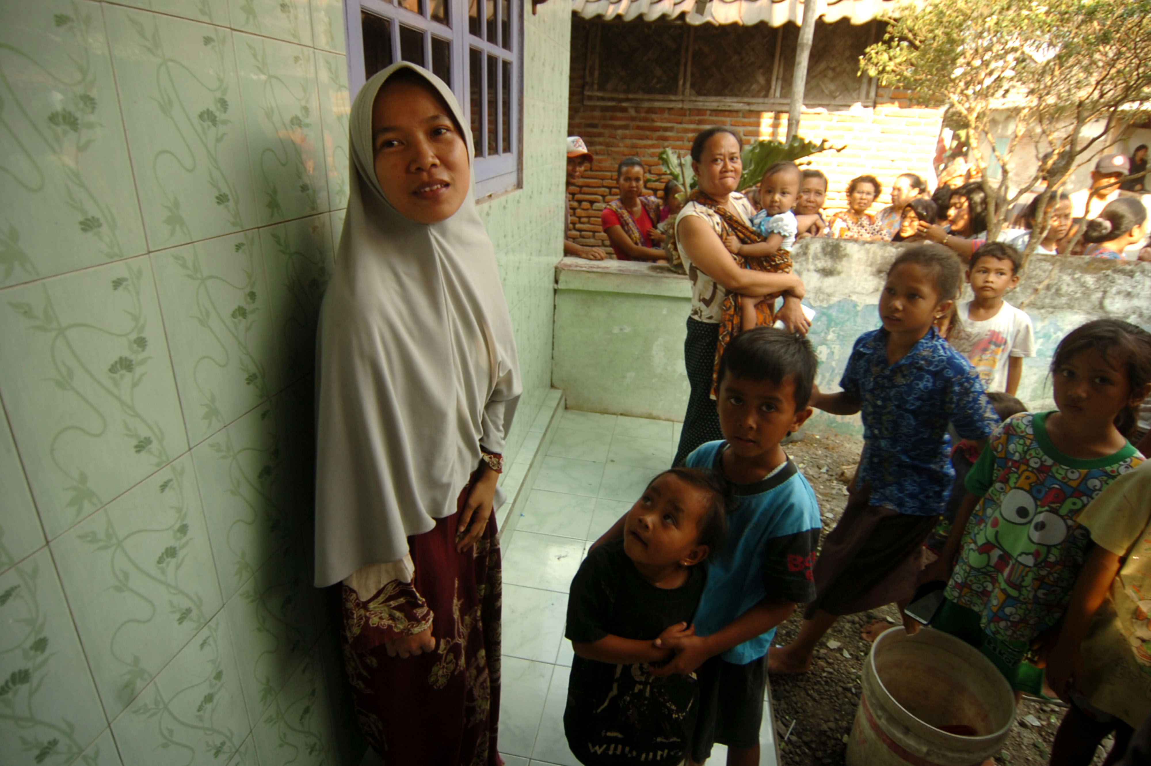 Keluarga Fitria Diana saat menyaksikan pemasangan garis polisi di rumahnya di Brebes, Jawa Tengah, Kamis (10/10).
