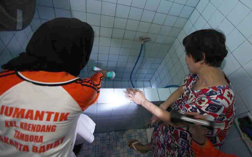 Petugas memeriksa bak penampungan air di rumah warga saat program pemberantasan sarang nyamuk di kawasan Krendang, Tambora, Jakarta Barat