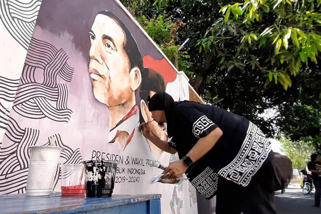 Warga Kampung Bocah Prigel, Laweyan, Solo, Jawa Tengah, menggambar mural presiden Indonesia dari masa ke masa, Jumat (18/10).