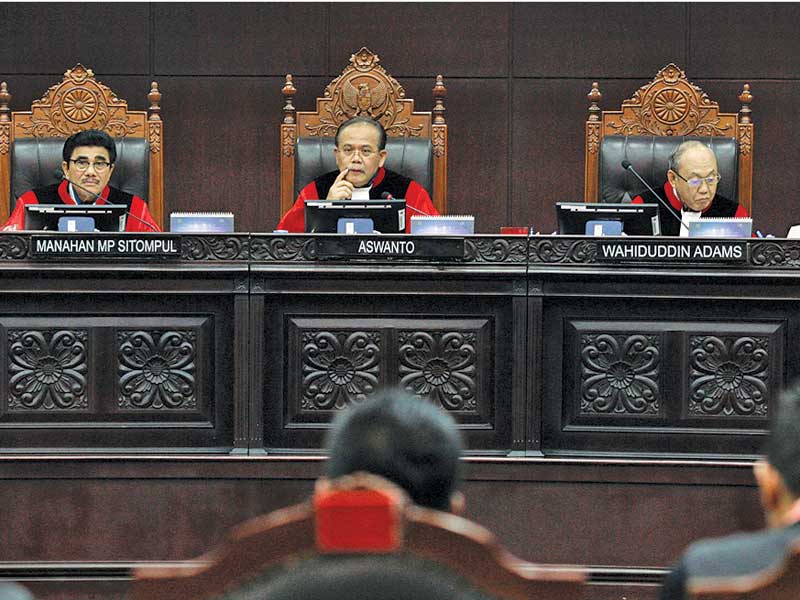 Ketua Majelis Hakim Konstitusi Aswanto (tengah) didampingi hakim Manahan MP Sitompul dan Wahiduddin Adams memimpin sidang pengujian UU.