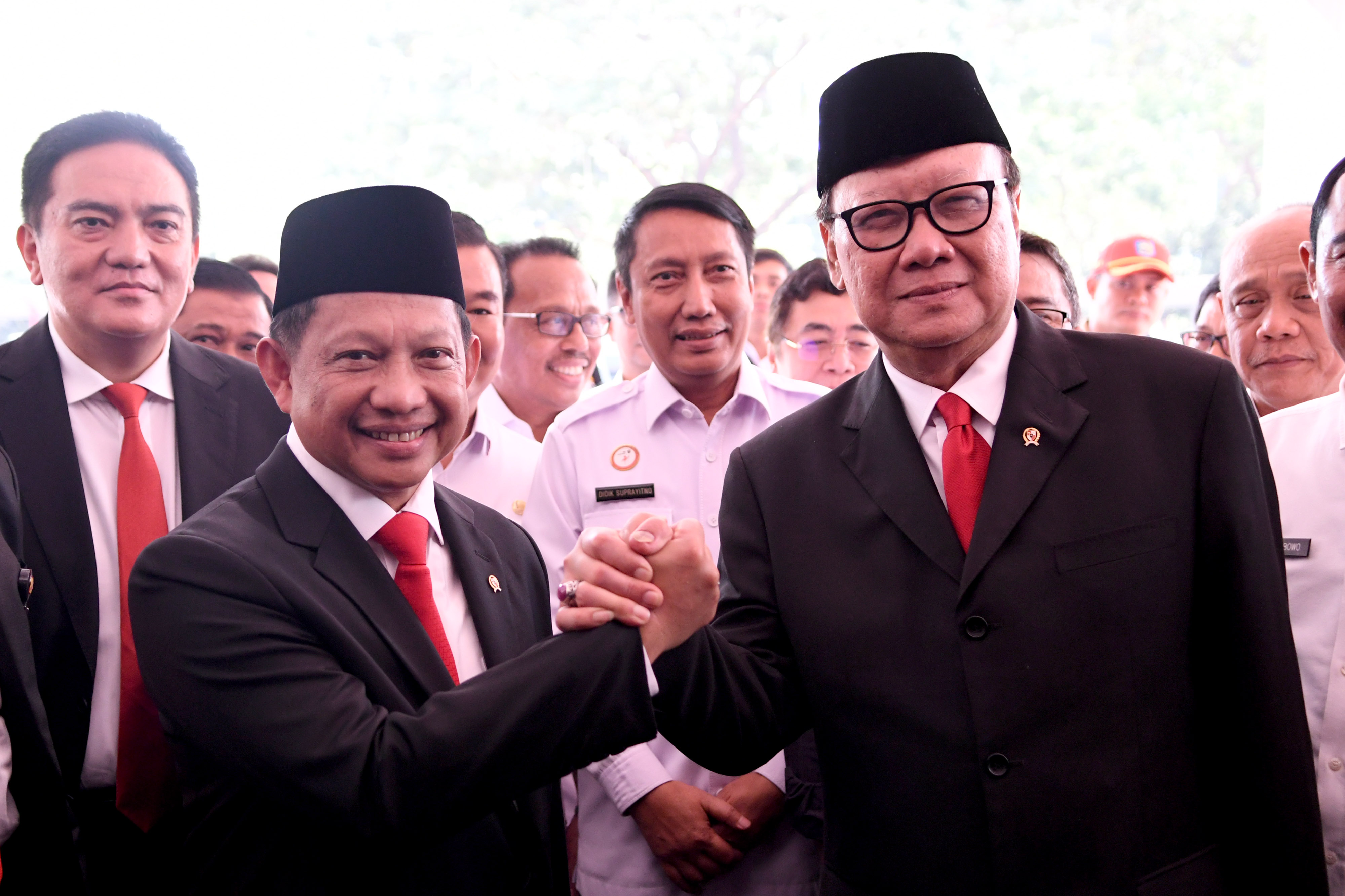 Menteri Dalam Negeri Tito Karnavian (kiri) berjabat tangan dengan pejabat lama Tjahjo Kumolo (kanan)