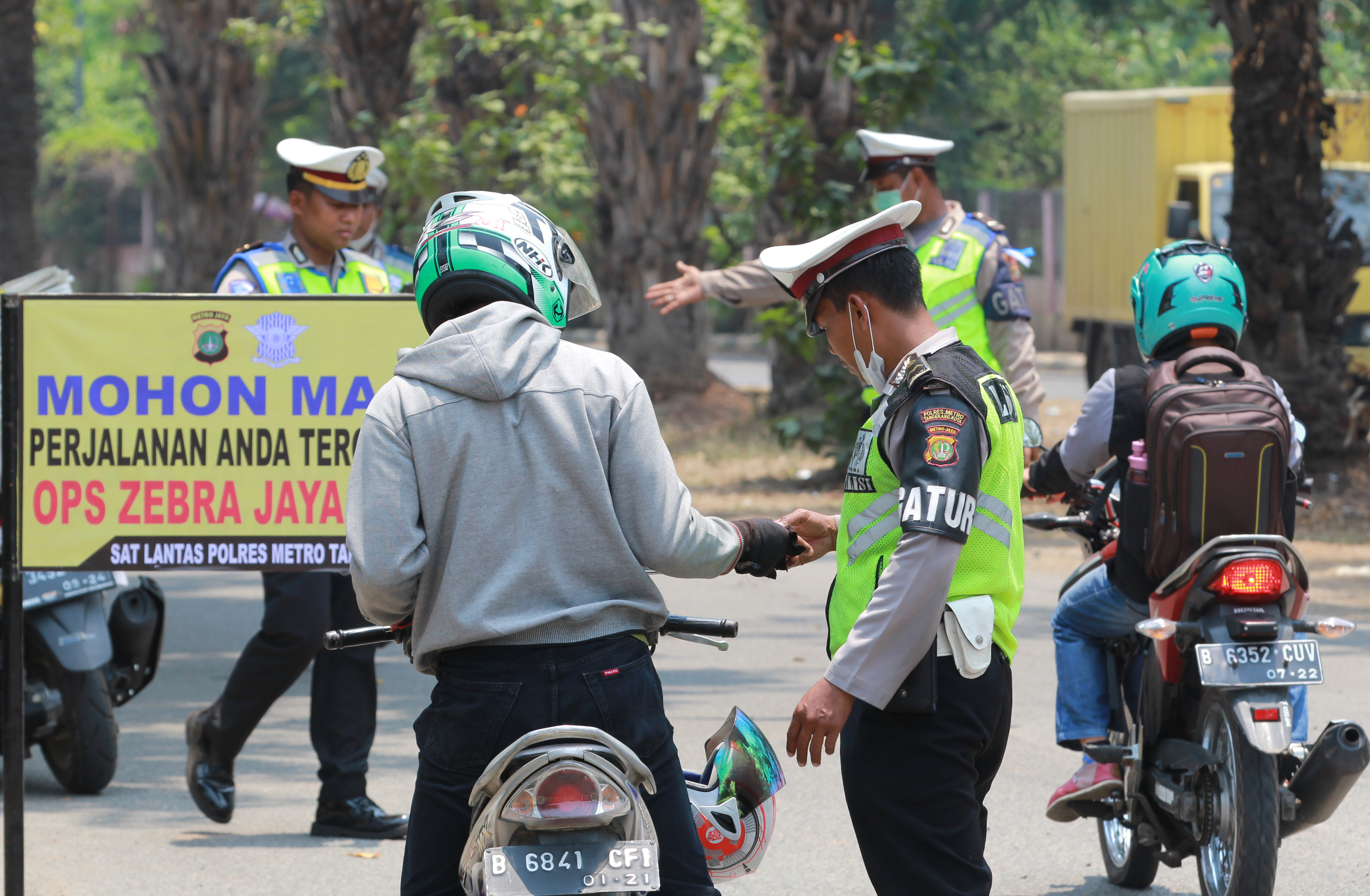 Petugas Polantas Polres Metropolitan Tangerang memeriksa kelengkapan surat-surat kendaraan bermotor saat dilaksanakannya Operasi Zebra 2019