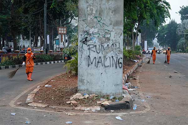 Petugas PPSU membersihkan sampah pascaaksi unjuk rasa di kawasan Lapangan Tembak, Senayan, Jakarta, Rabu (25/9/2019).