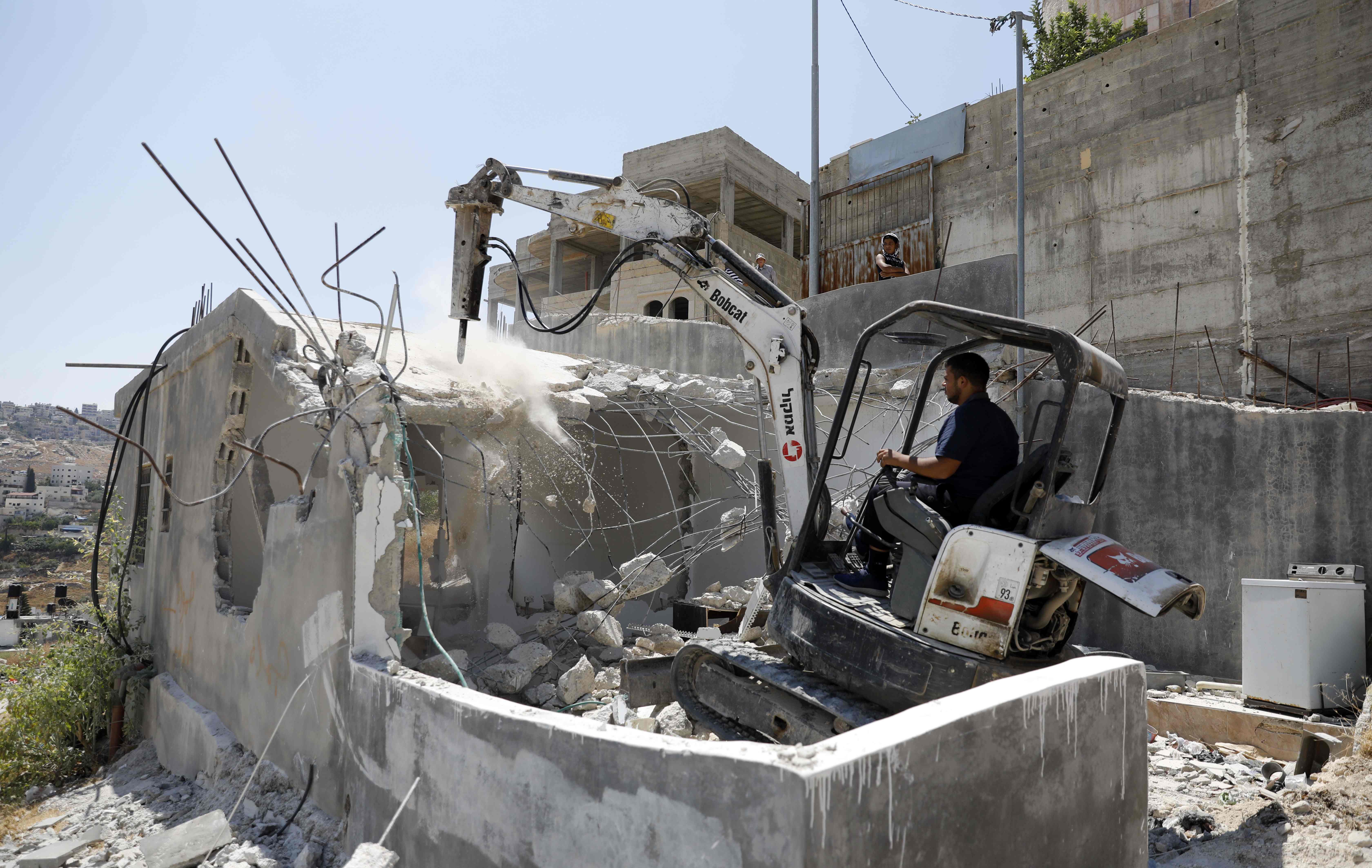 Seorang warga Palestina membongkar rumahnya sendiri di Jerusalem Timur.
