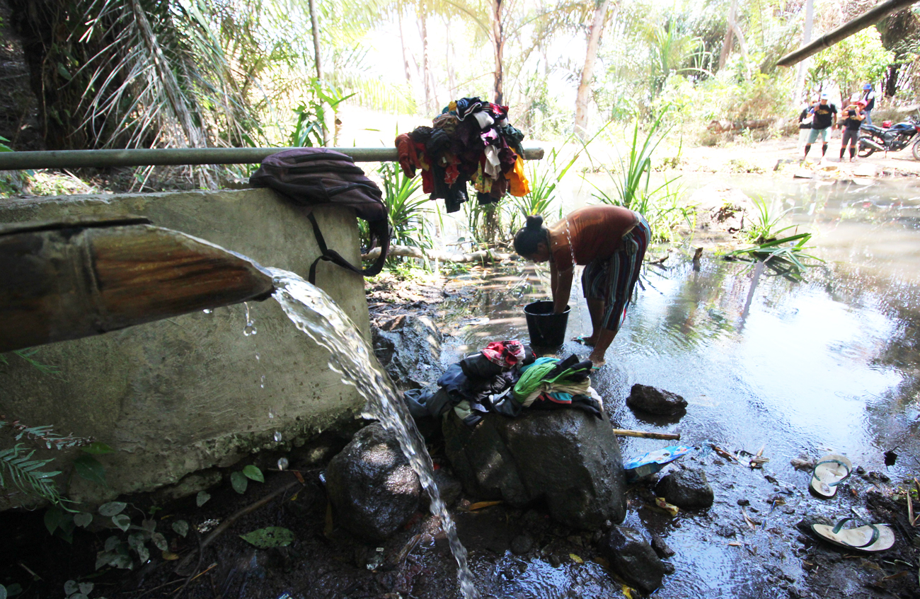 Warga desa sedang mencuci pakaian di mata air Aegeru di Desa Tedakise, Kacamatan Aesesa, Kabupaten Nagekeo, Nusa Tenggara Timur.