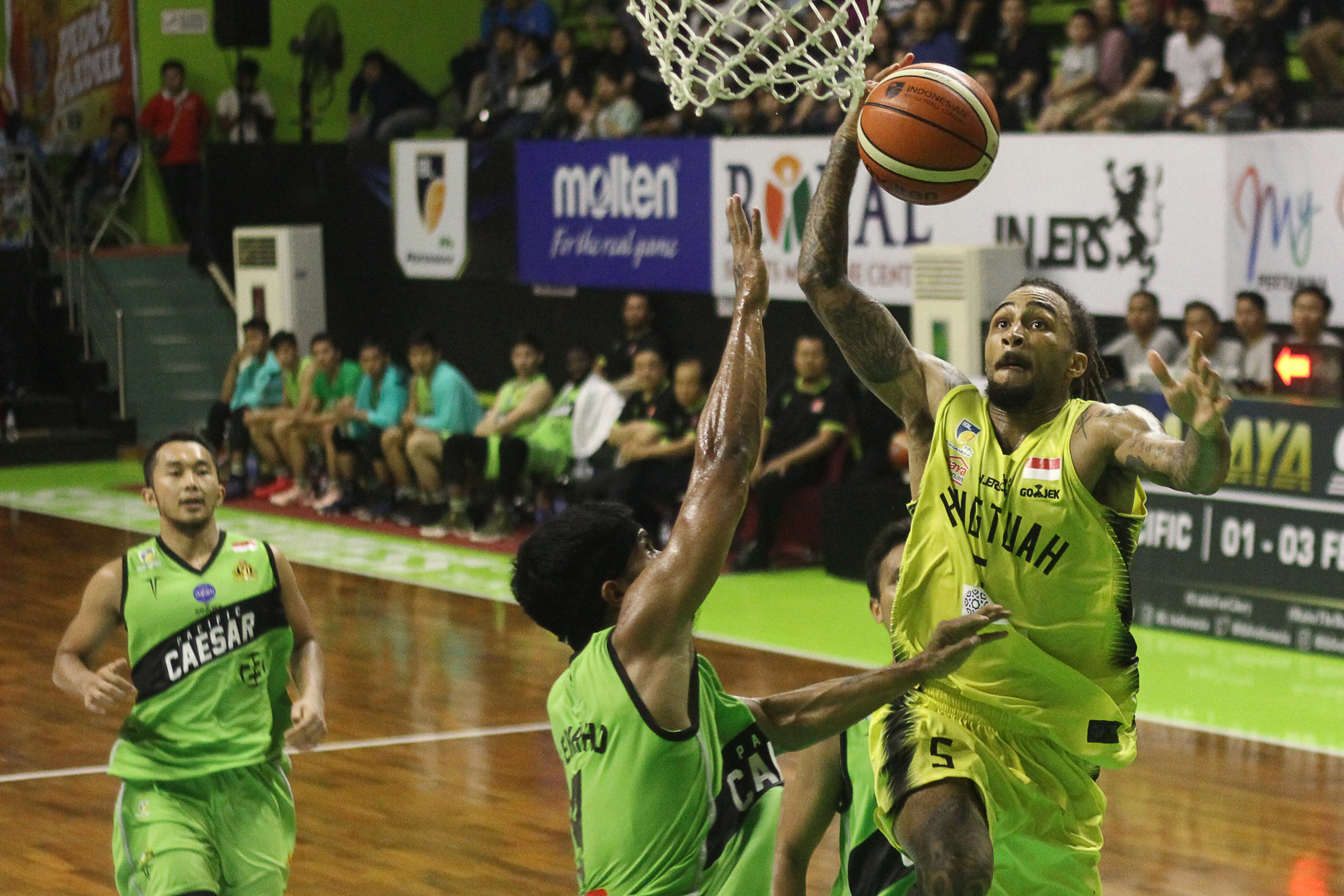  Pebasket Hangtuah Gary Jacobs (kanan) berusaha melakukan lay up melewati hadangan pebasket Pasific Caesar Surabaya Yerikho Tuasela