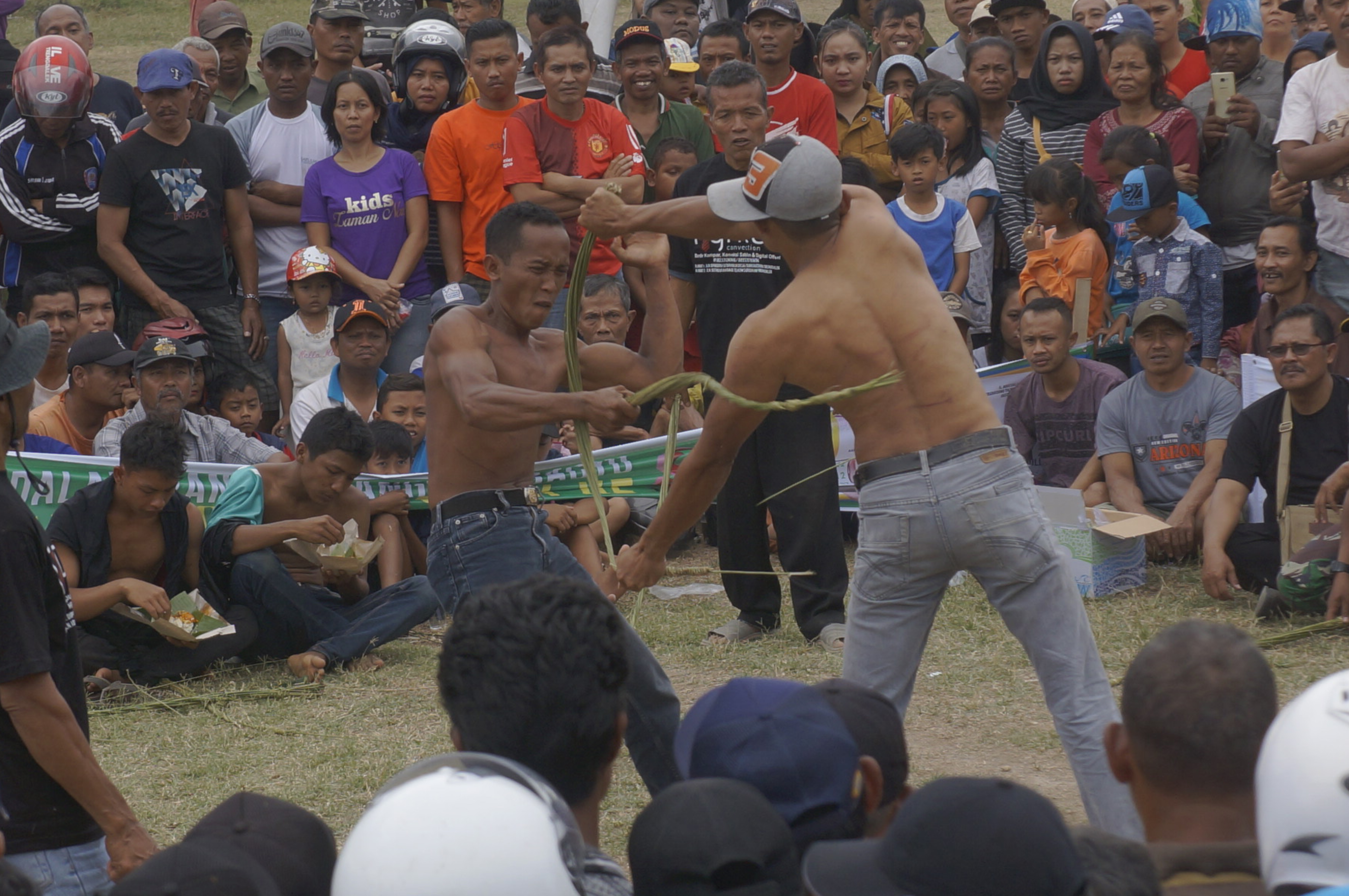Dua orang saling mencambuk dalam rangka ritual Tiban untuk memanggil hujan. 