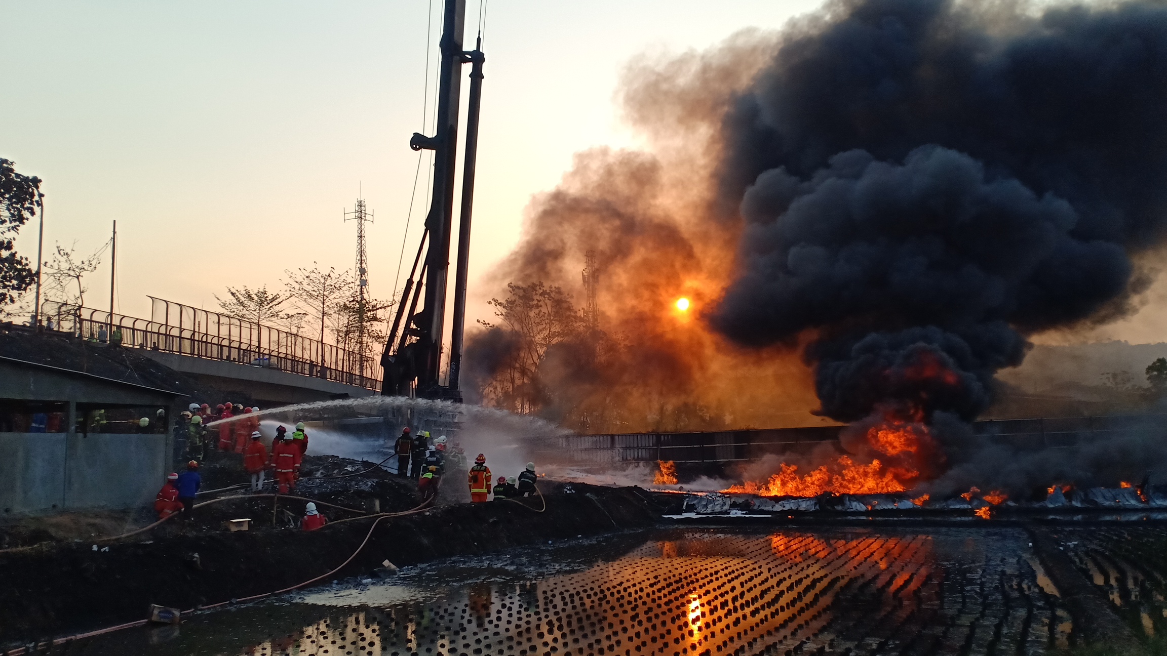Petugas pemadam berusaha memadamkan kobaran api yang membakar pipa minyak di Kota Cimahi, Jabar, dengan cairan khusus, Selasa (22/10).