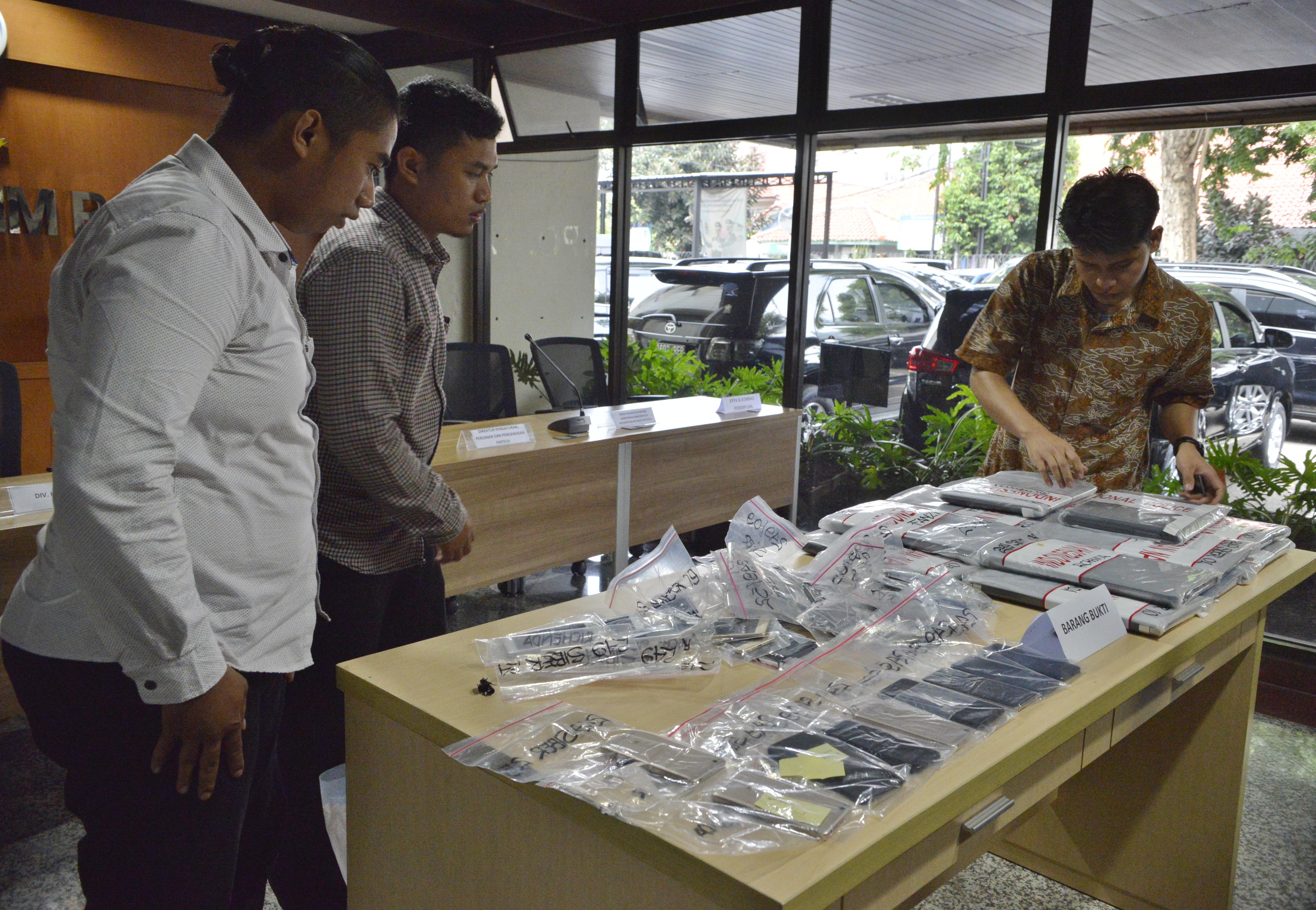ilustrasi -- Petugas Polisi menata barang bukti kejahatan fintech ilegal. 