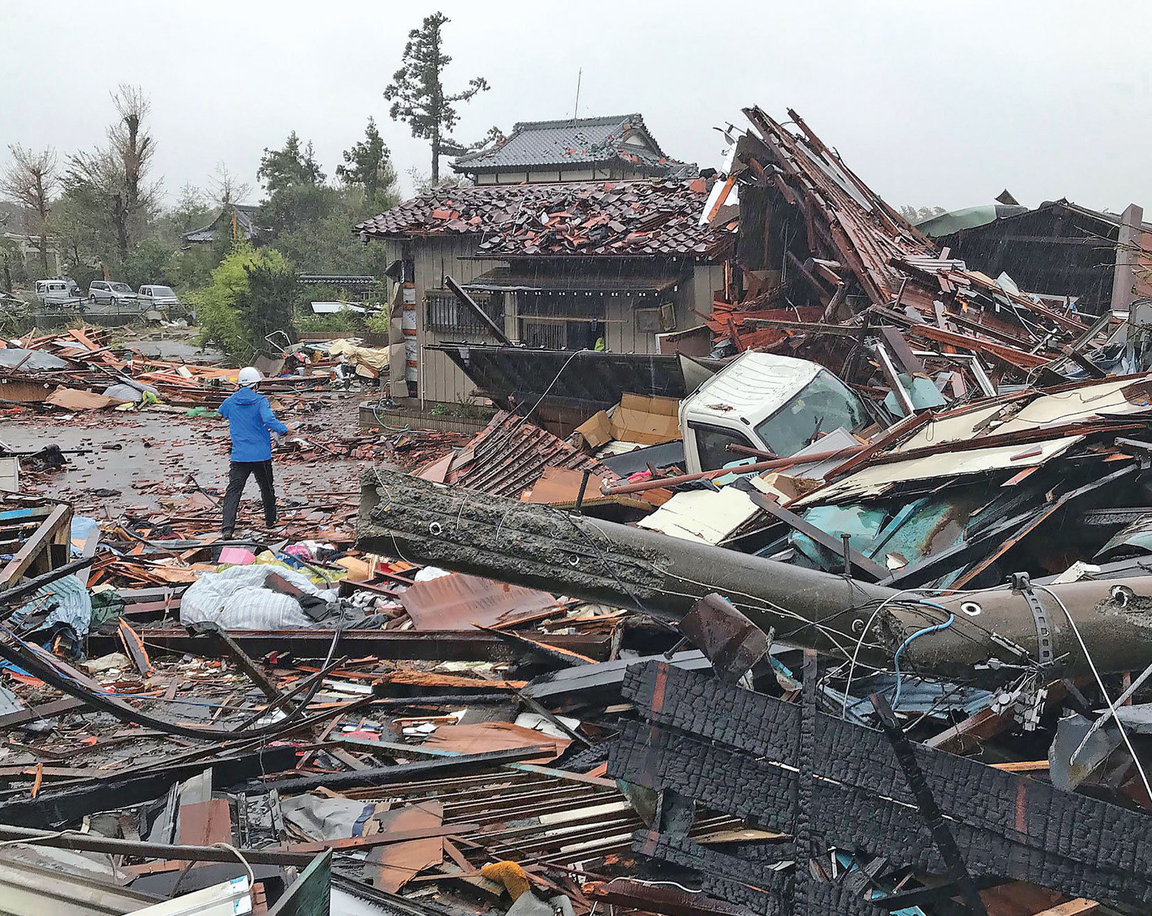 Topan Hagibis yang berkekuatan dahsyat melanda Jepang disertai dengan hujan deras, kemarin. (Foto kiri) rumah-rumah hancur setelah diterjang