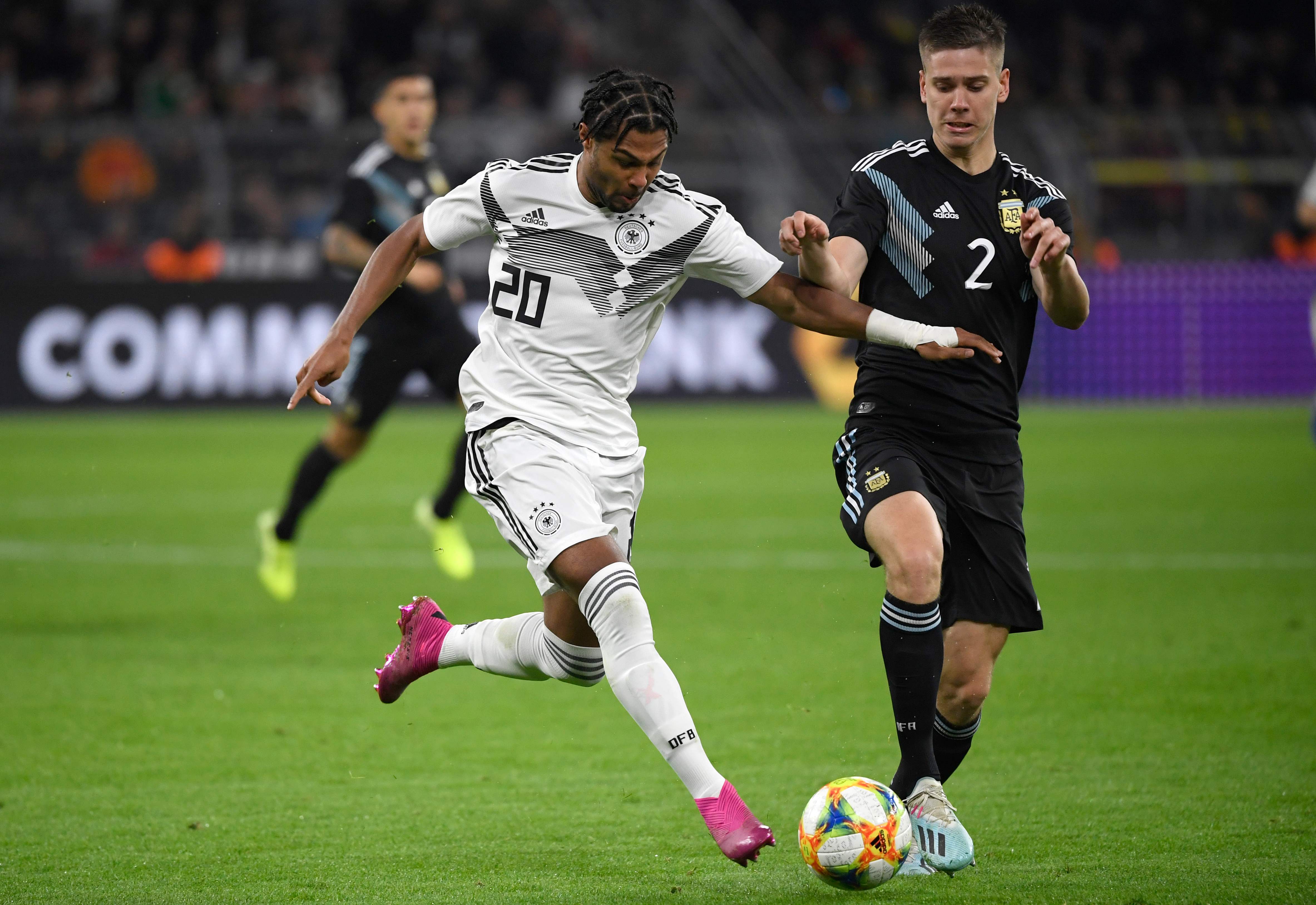 Penyerang Jerman Serge Gnabry (kiri) berduel dengan pemain belakang Argentina Juan Foyth