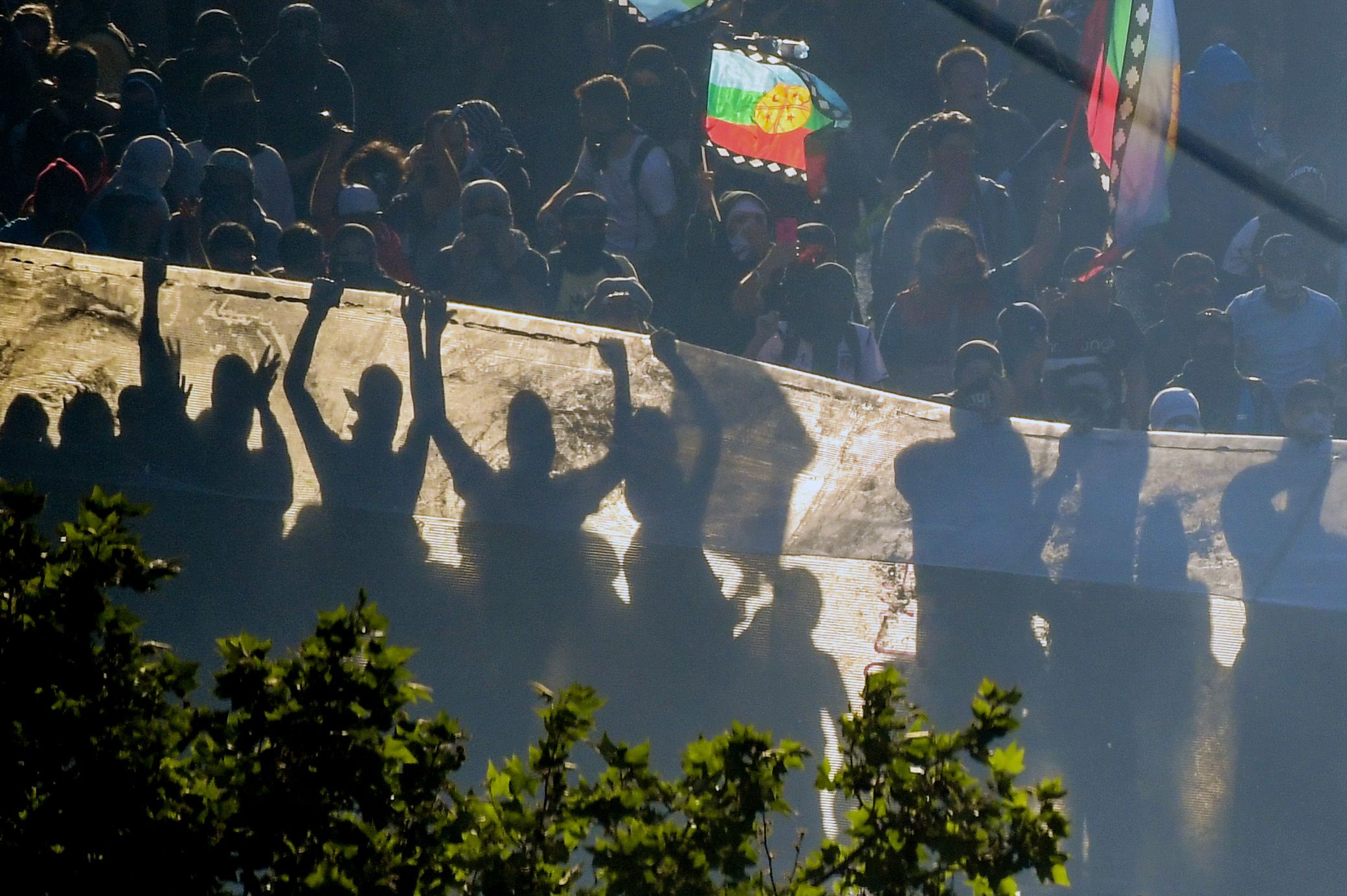 Demonstran beraksi di antara kepulan asap di Santiago, Cile.