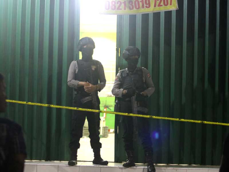 Petugas kepolisian berjaga saat penggeledahan sebuah ruko yang dihuni terduga teroris di Indramayu, Jawa Barat, Minggu (13/10) malam