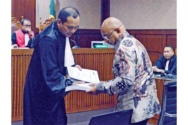 Terdakwa kasus dugaan suap proyek pengadaan di lingkungan PT Krakatau Steel Karunia Alexander Muskitta (kanan) menerima berkas tuntutan