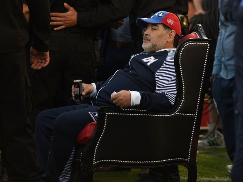 Maradona duduk di kursi khusus yang diberikan Newell's Old Boys saat memimpin Gimnasia La Plata.