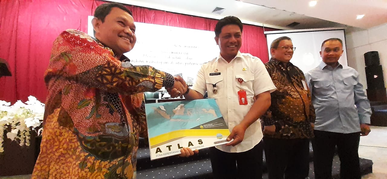 Kepala Badan Geologi Rudy Suhendar (berbaju putih) menyerahkan buku Atlas Kerentanan Likuefaksi di Indonesia kepada Sekda Provinsi Sulteng.
