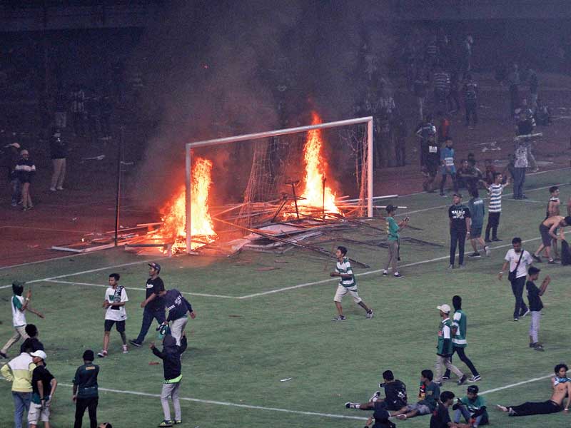 Suporter Persebaya membakar papan sponsor usai pertandingan Liga 1 2019 antara Persebaya dan PSS Sleman di Stadion Gelora Bung Tomo/