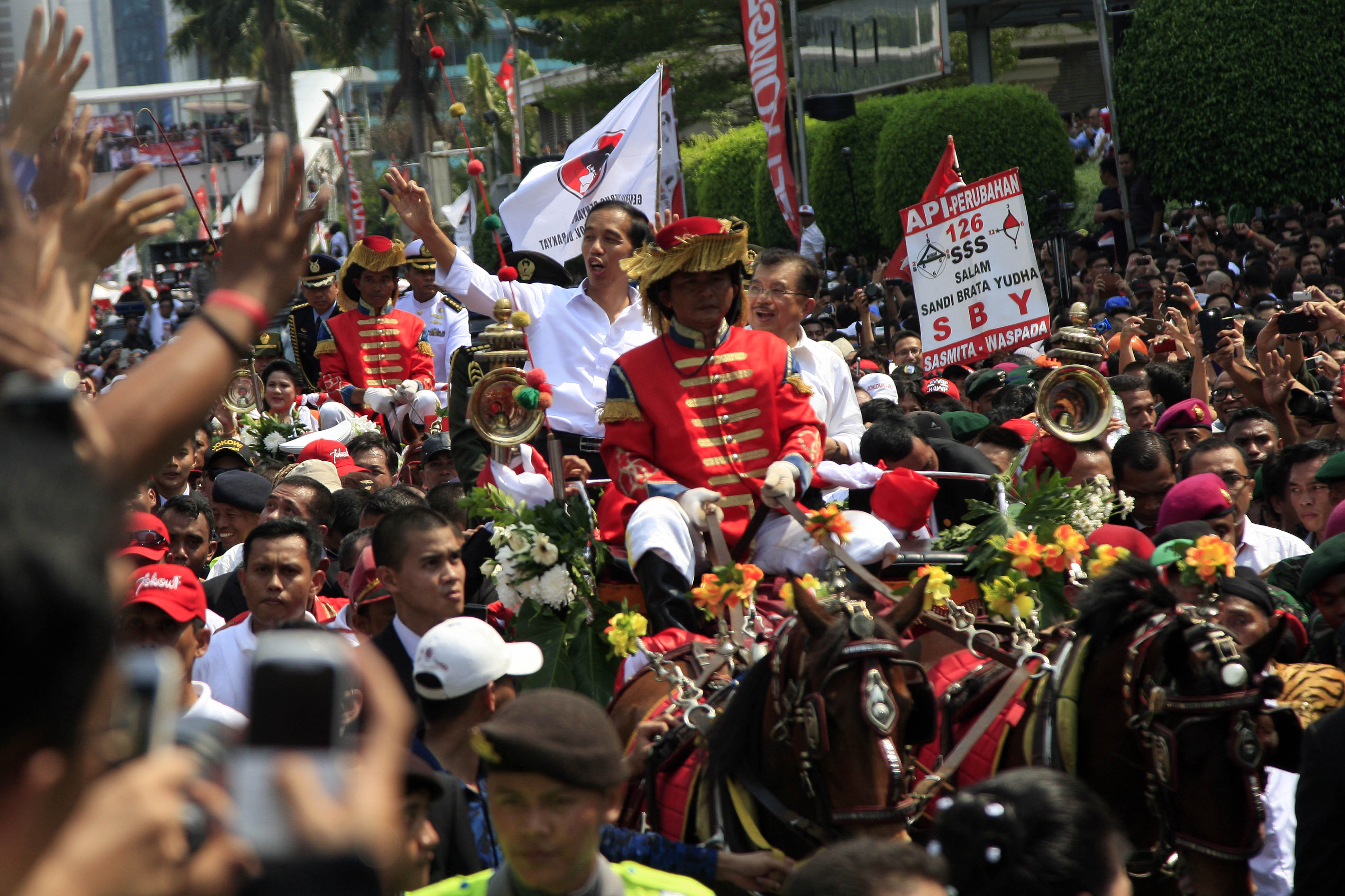 Presiden Joko Widodo dan Wapres Jusuf Kalla dengan menaiki Kereta Kencana saat menuju Istana Kepresidenan, Jakarta, Senin (20/10/2014).