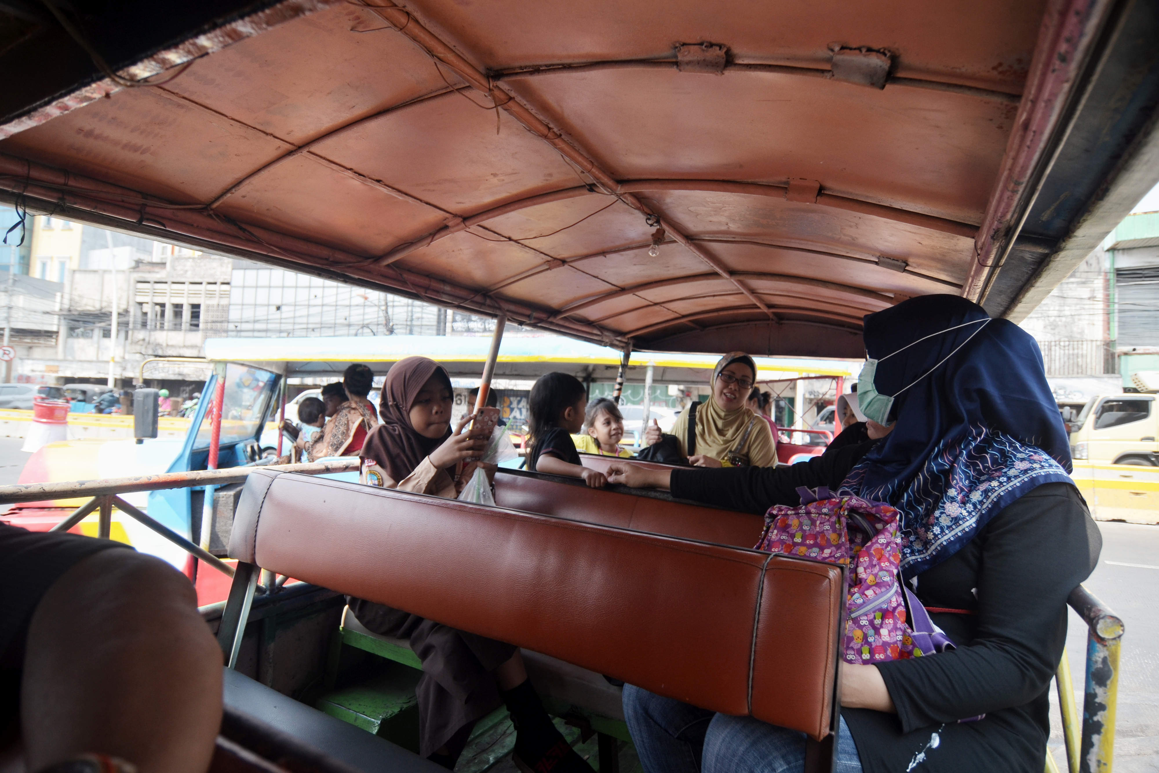 Warga menaiki odong-odong di Kampung Pulo, Jakarta Timur