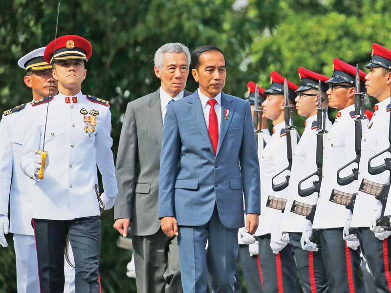 Presiden Joko Widodo dengan didampingi Perdana Menteri Singapura Lee Hsien Loong melakukan inspeksi pasukan saat upacara penyambutan di Ista