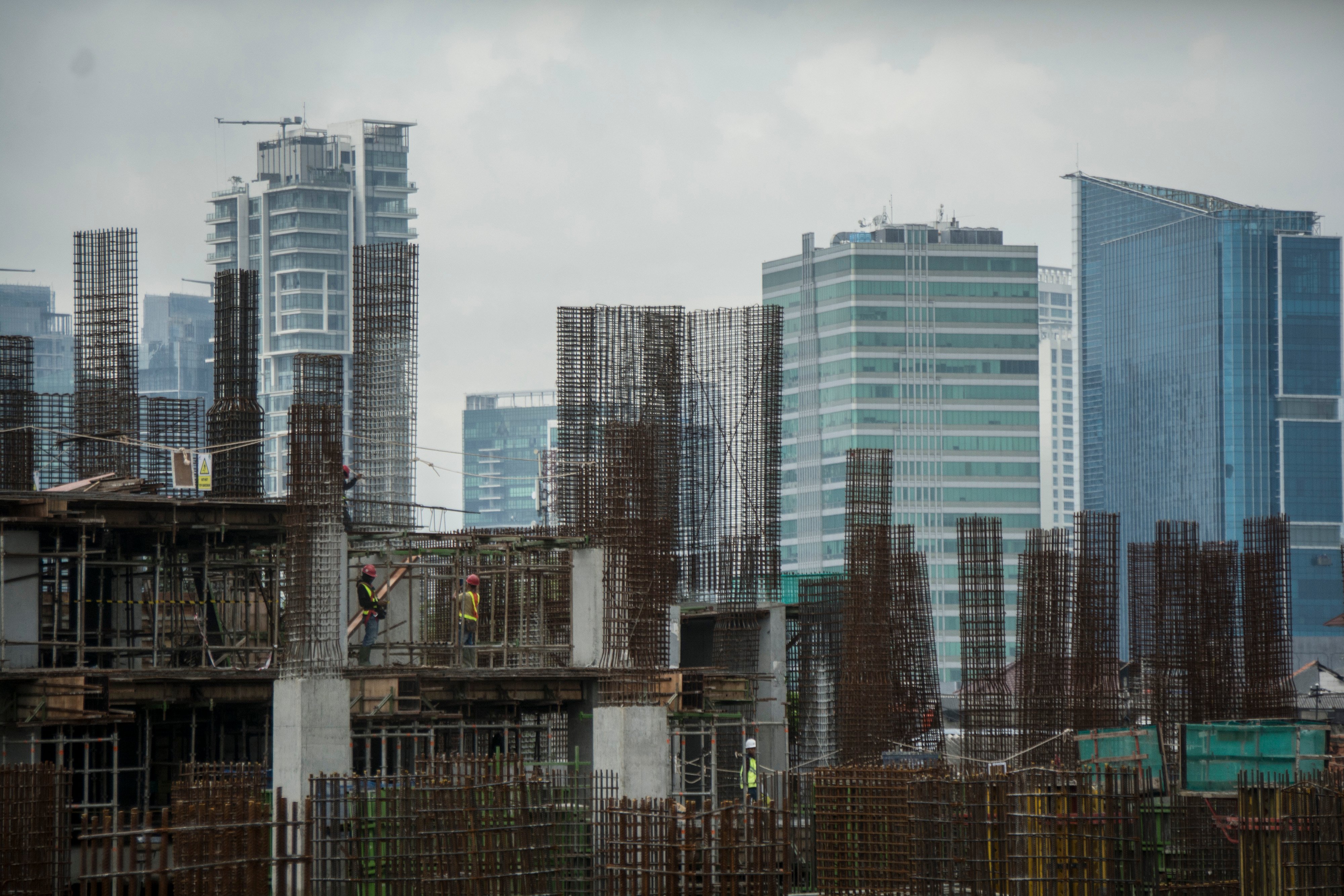 Pekerja menyelesaikan pembangunan gedung bertingkat di Jakarta, beberapa waktu lalu.