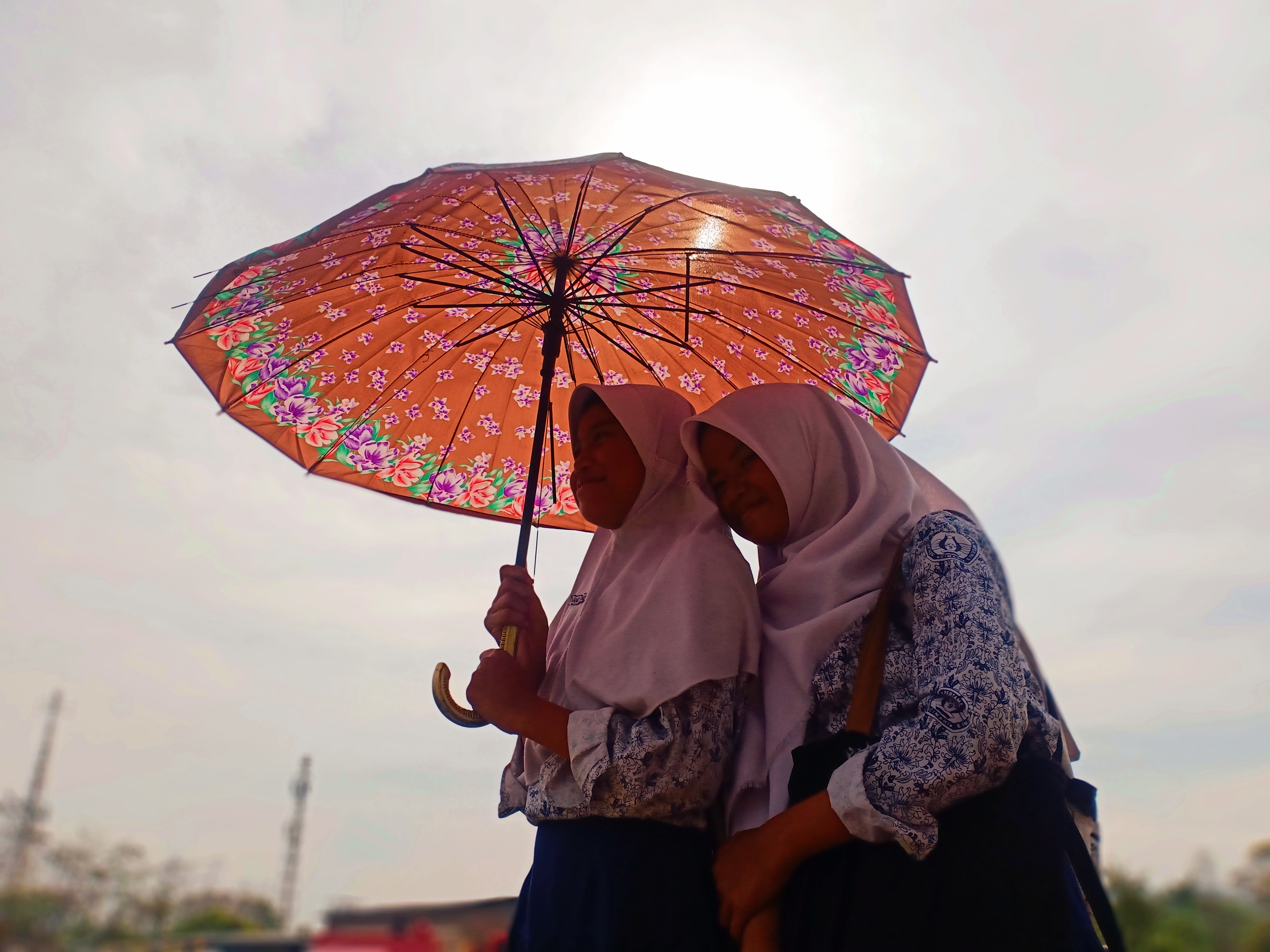 Pelajar memakai payung saat cuaca panas mendera wilayah Cimahi dan sekitarnya.