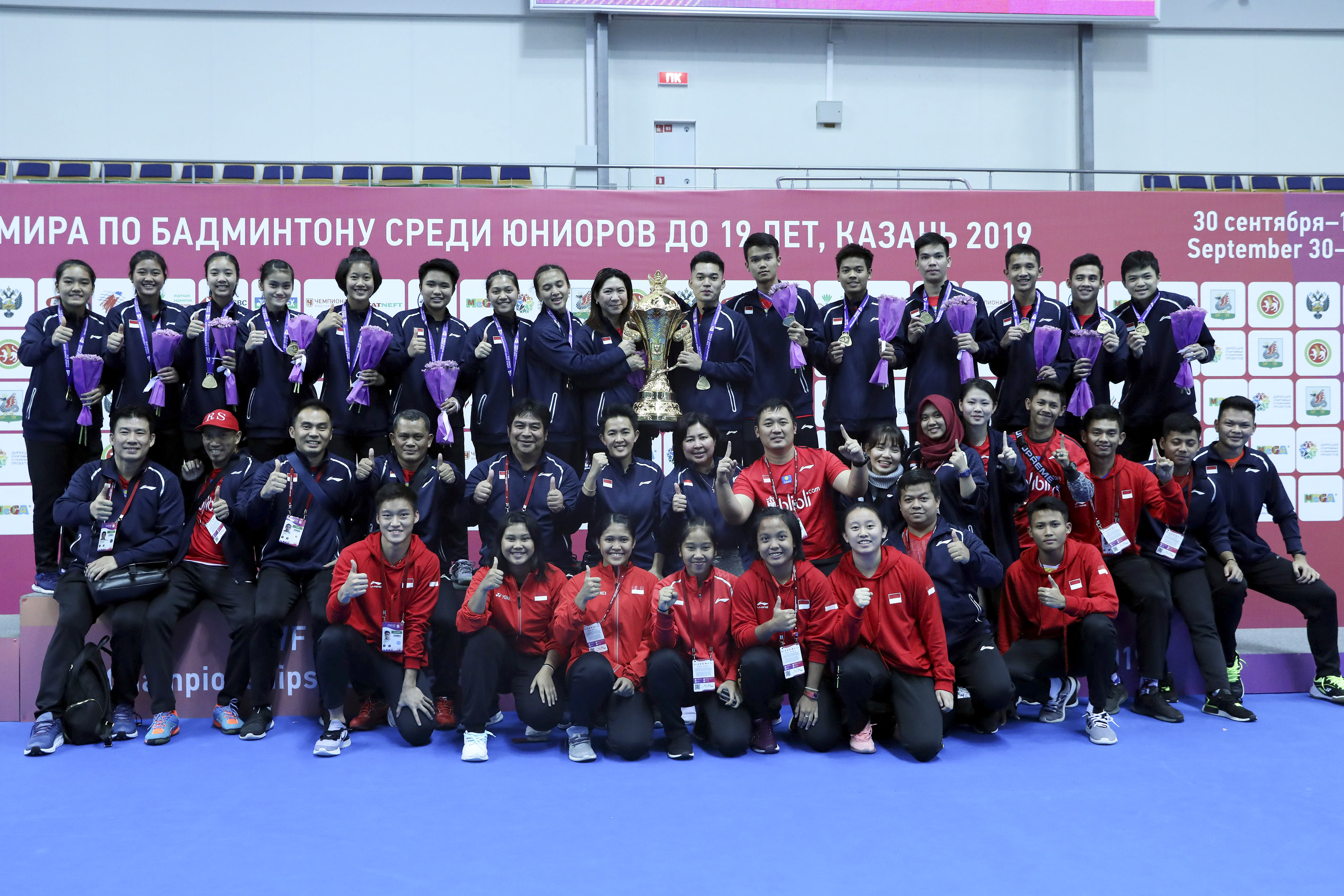 Pebulu tangkis junior Indonesia bersama pelatih dan ofisial menunjukkan piala usai upacara penyerahan medali final Kejuaraan Dunia Junior.