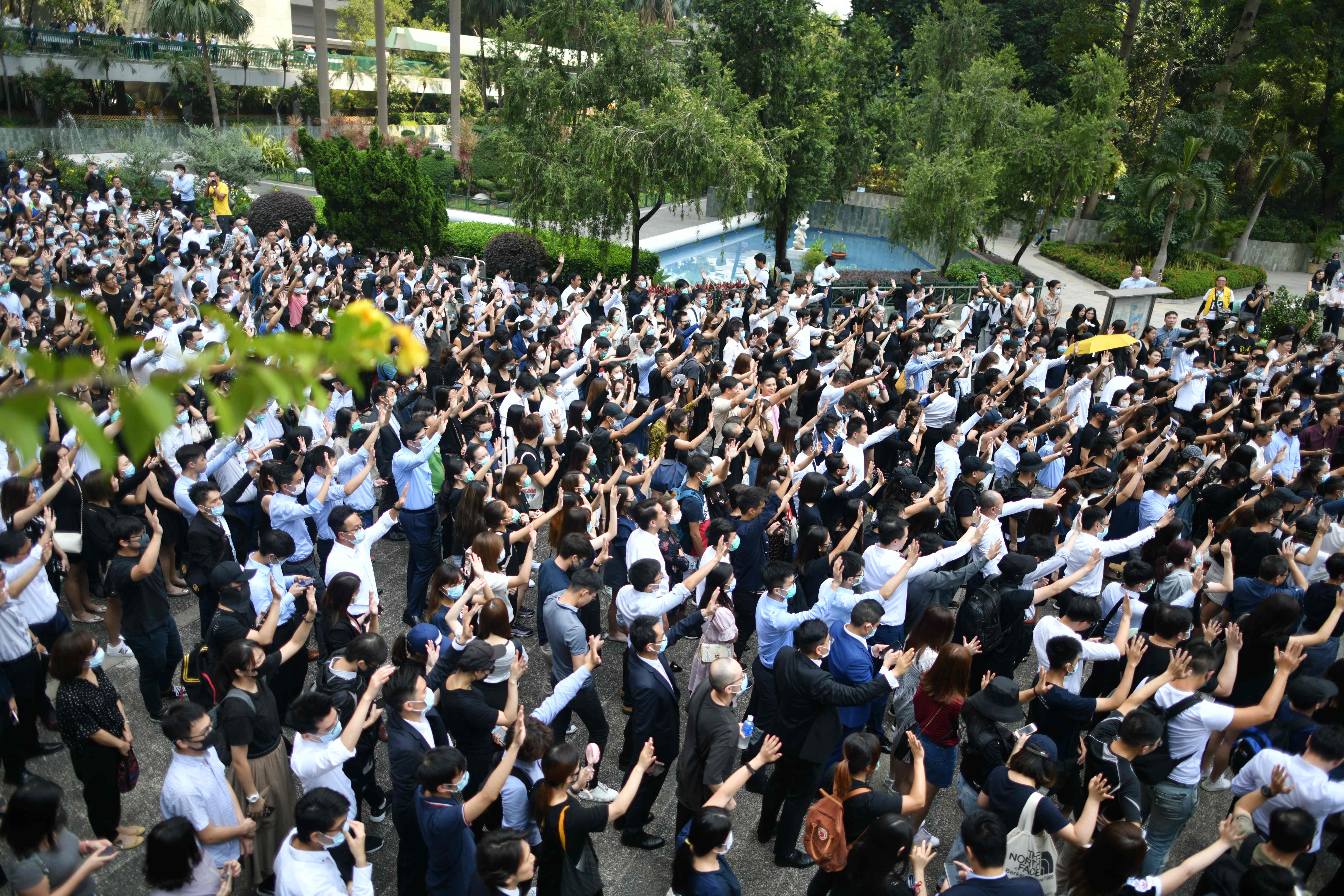 Demonstran mengangkat tangan dengan lima jari sebagai bentuk lima tuntutan saat lakukan flash mob di Chater Garden, Hong Kong, Selasa (2/10)