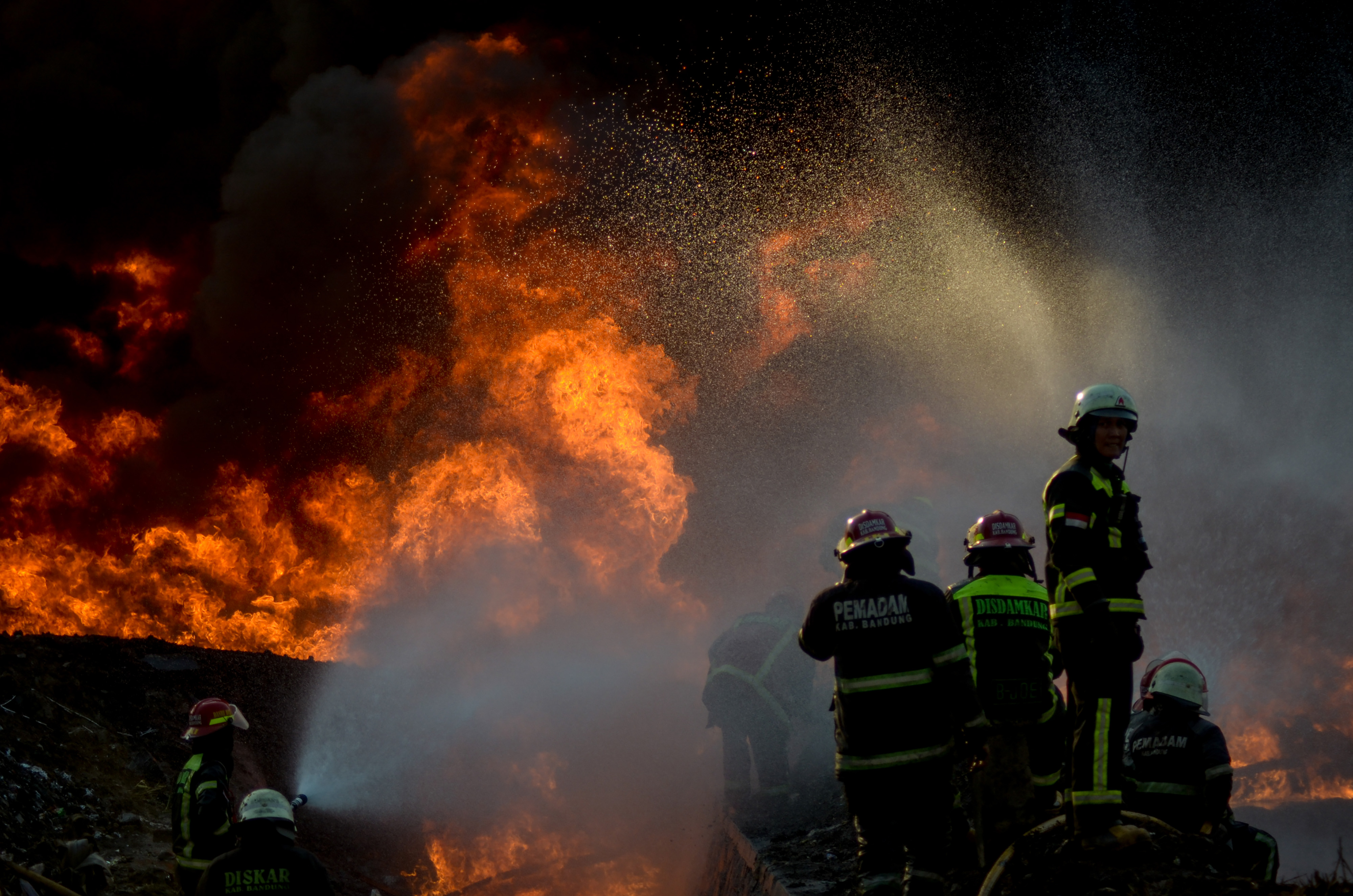 Petugas berusaha memadamkan api saat kebakaran pipa minyak milik PT Pertamina di Melong, Cimahi, Jawa Barat, Selasa (22/10).