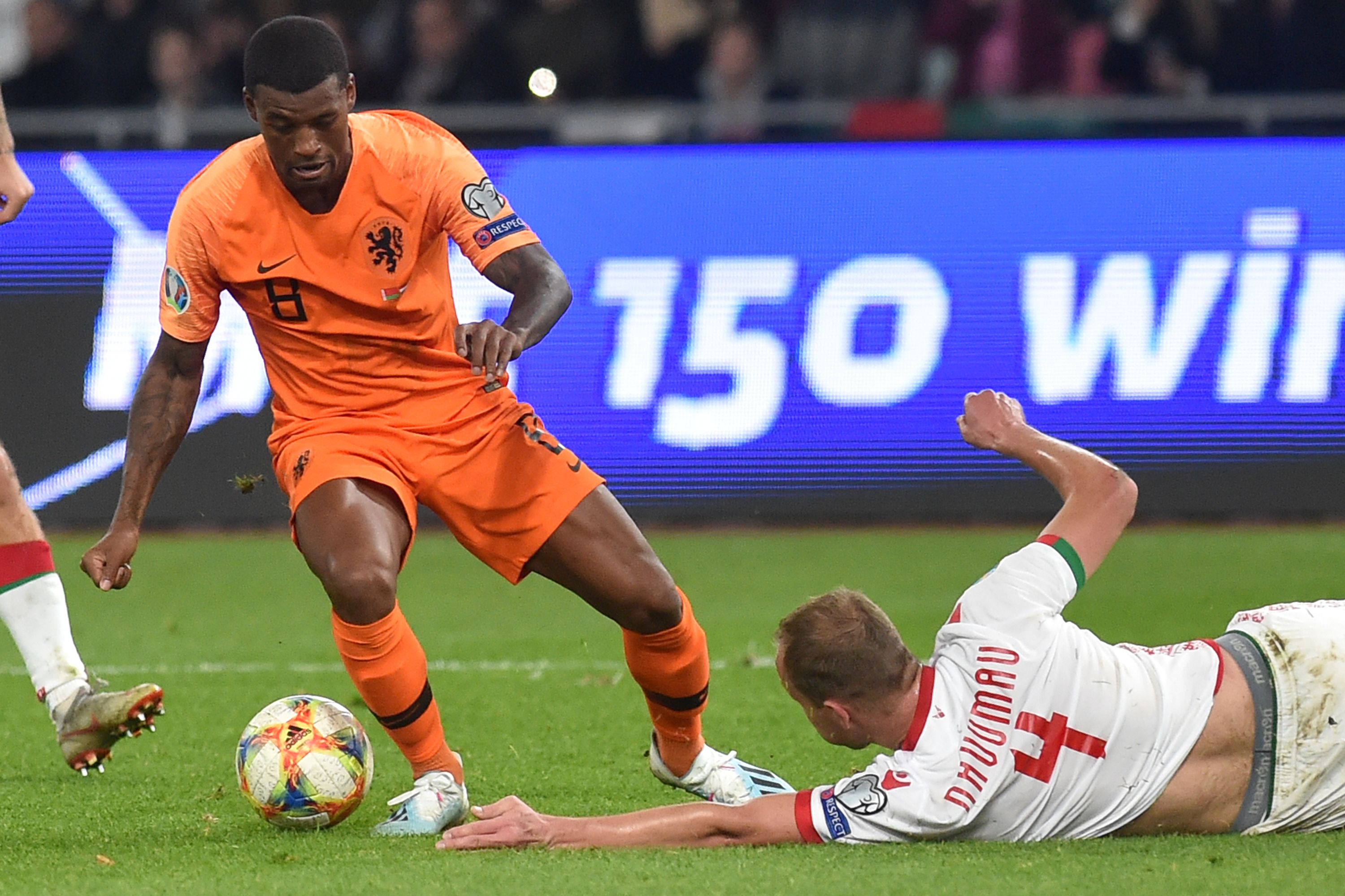 Gelandang Belanda Georginio Wijnaldum (kiri) mengecoh pemain belakang Belarus, Nikita Naumov.