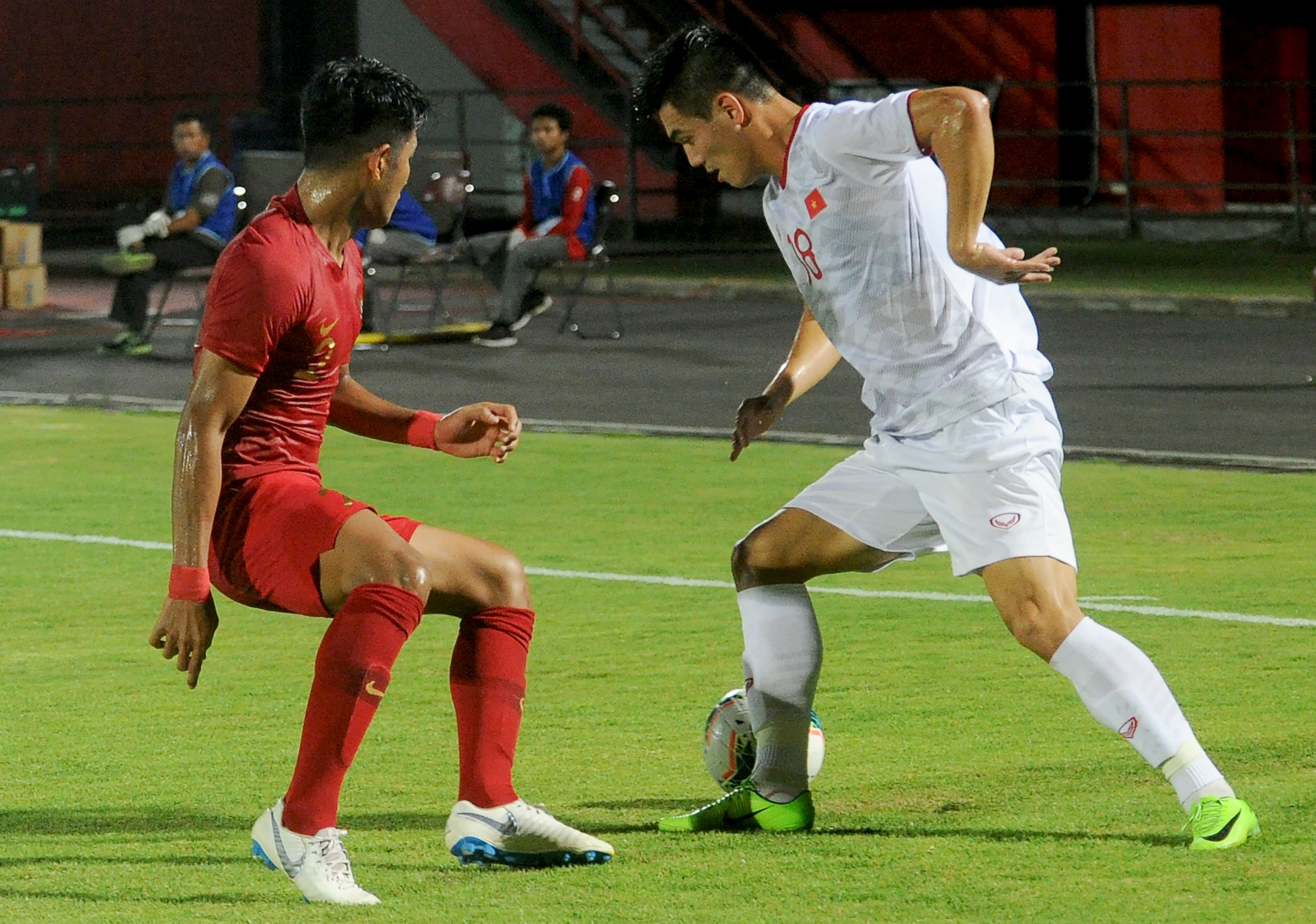 Pemai Indonesia Putu Gede Juni Antara berebut bola denga pemain Vietnam Nguyen Tien Linh