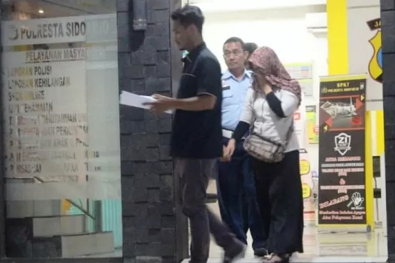 Istri anggota Satpomau Lanud Muljono Surabaya Peltu YNS, FS, seusai pemeriksaan di Polresta Sidoarjo, Sabtu (12/10)