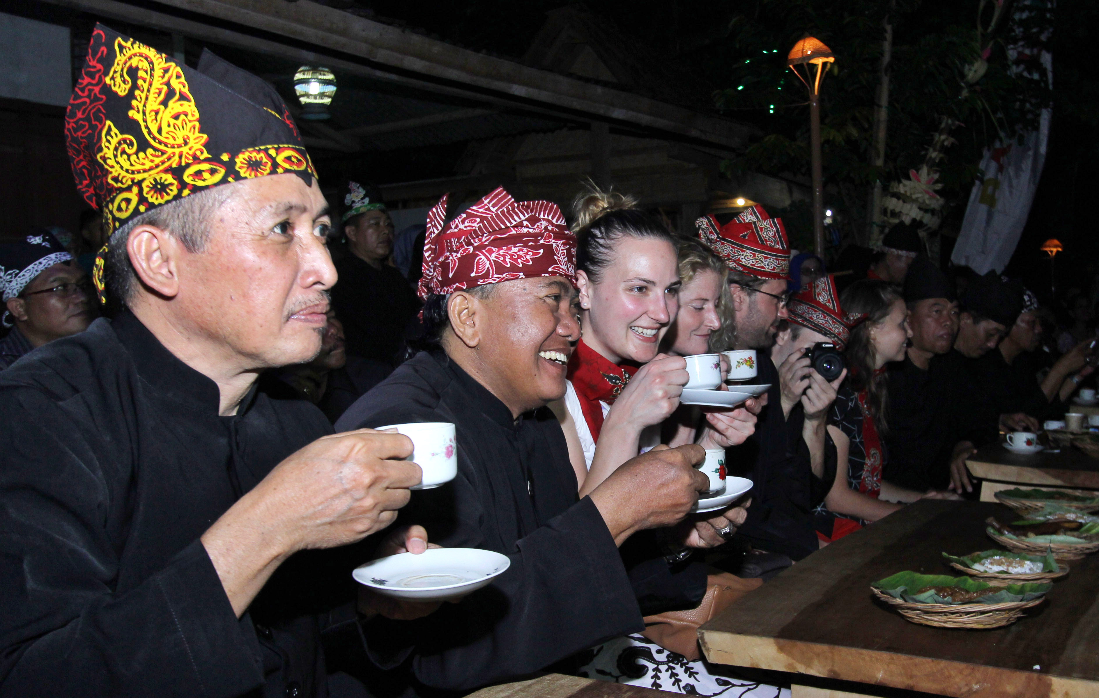  Sejumlah wisatawan asing menikmati kopi gratis saat menghadiri Festival Ngopi Sepuluhewu (Sepuluh ribu Kopi) di Kemiren, Banyuwangi,