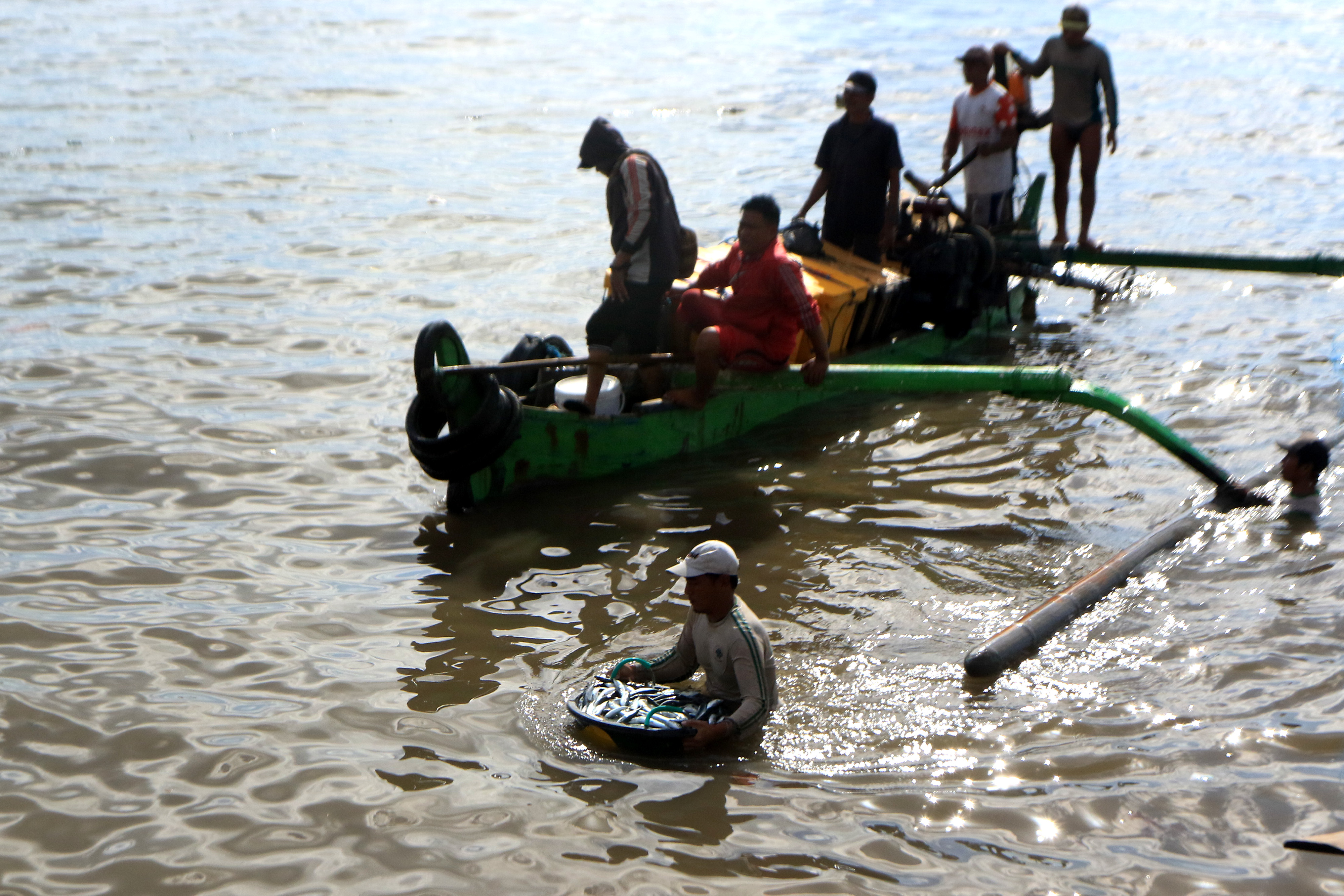 Nelayan Banyuwangi membawa ikan hasil tangkapannya.