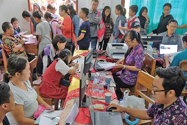 Calon peserta didik baru mengikuti proses verifi kasi berkas dan pengambilan kode akun dalam pendaftaran Penerimaan Peserta Didik Baru (PPDB