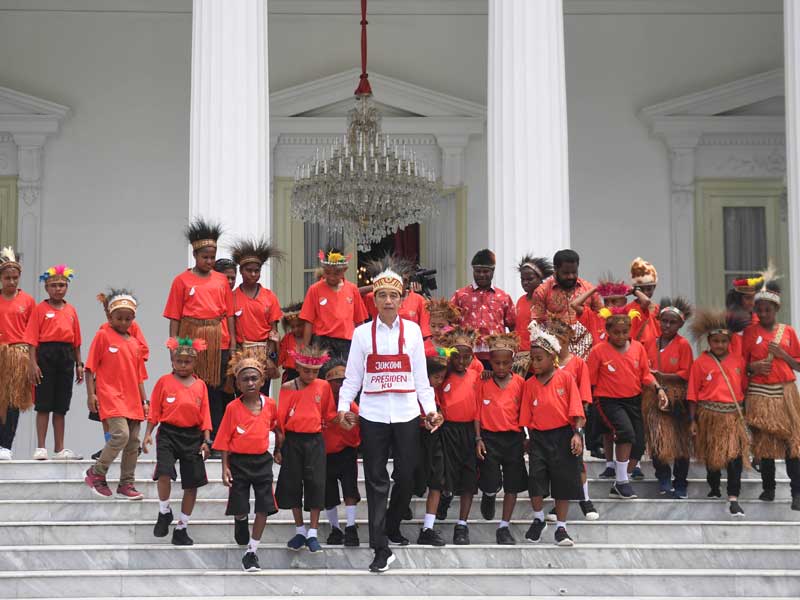 Presiden Joko Widodo berjalan bersama anak-anak perwakilan siswa SD di Jayapura dan Asmat, Papua, di Istana Merdeka, Jakarta, Jumat (11/10/2