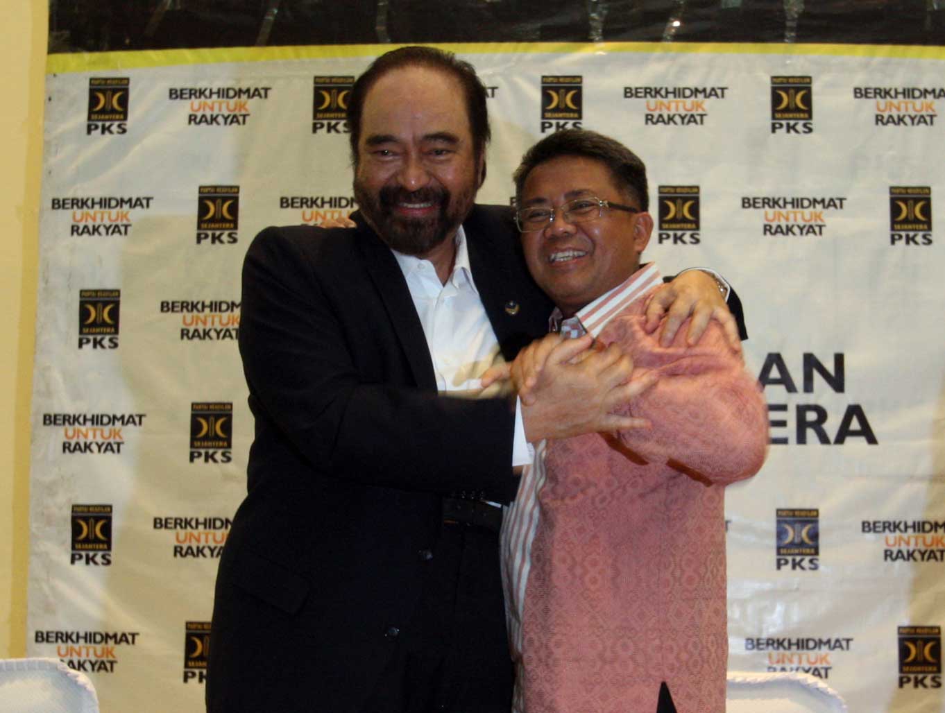 Ketua Umum Partai Nasional Demokrat (NasDem) Surya Paloh (kiri) berpelukan dengan Presiden Partai Keadilan Sejahtera (PKS) Sohibul Iman.