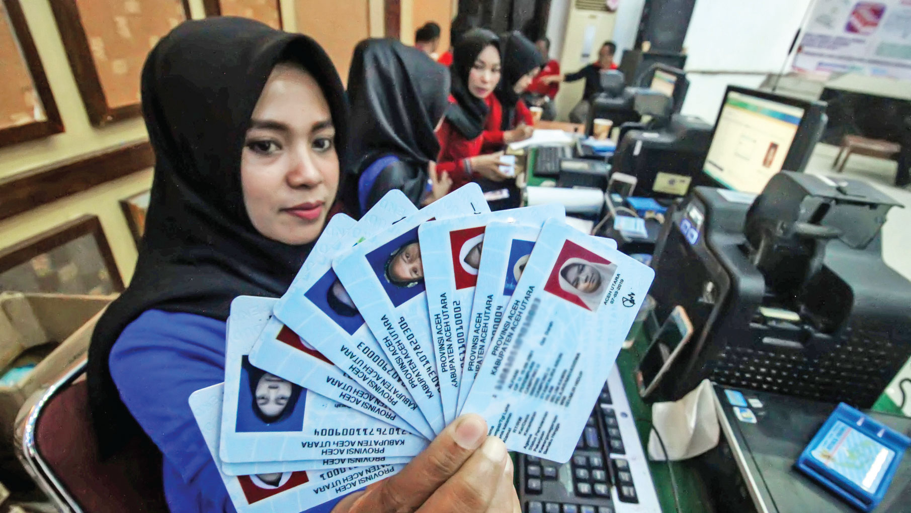 Petugas menunjukkan kartu tanda penduduk elektronik perekaman massal Gerakan Indonesia Sadar Adminitrasi Kependudukan di GOR Unimal Cunda