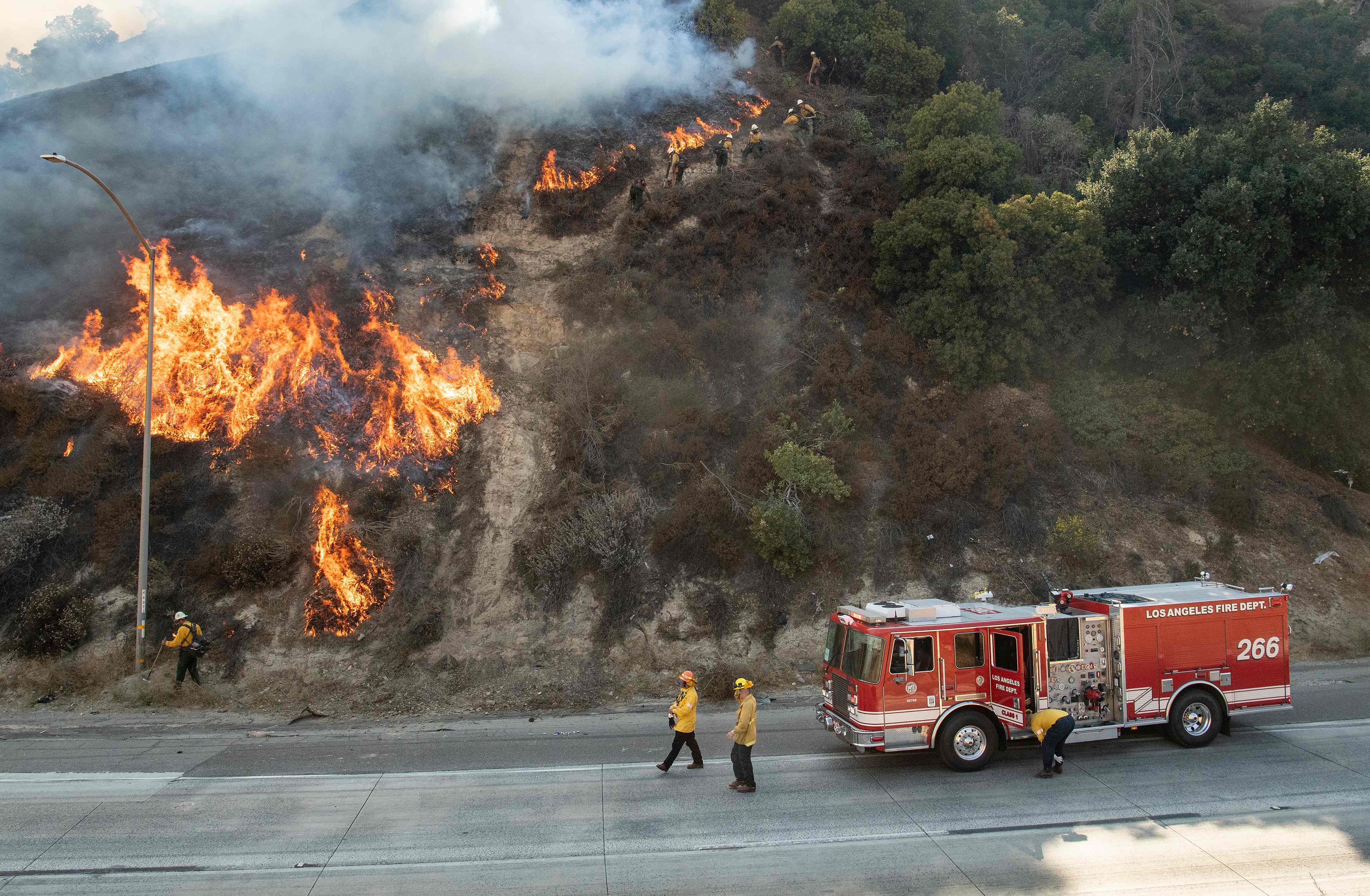 Petugas pemadam kebakaran mengawasi api yang melanda wilayah Newhall, California