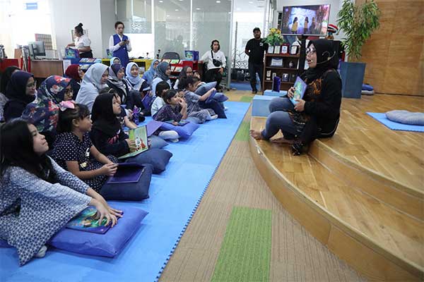 Anak-anak mendengarkan dongeng di gedung perpustakaan nasional.