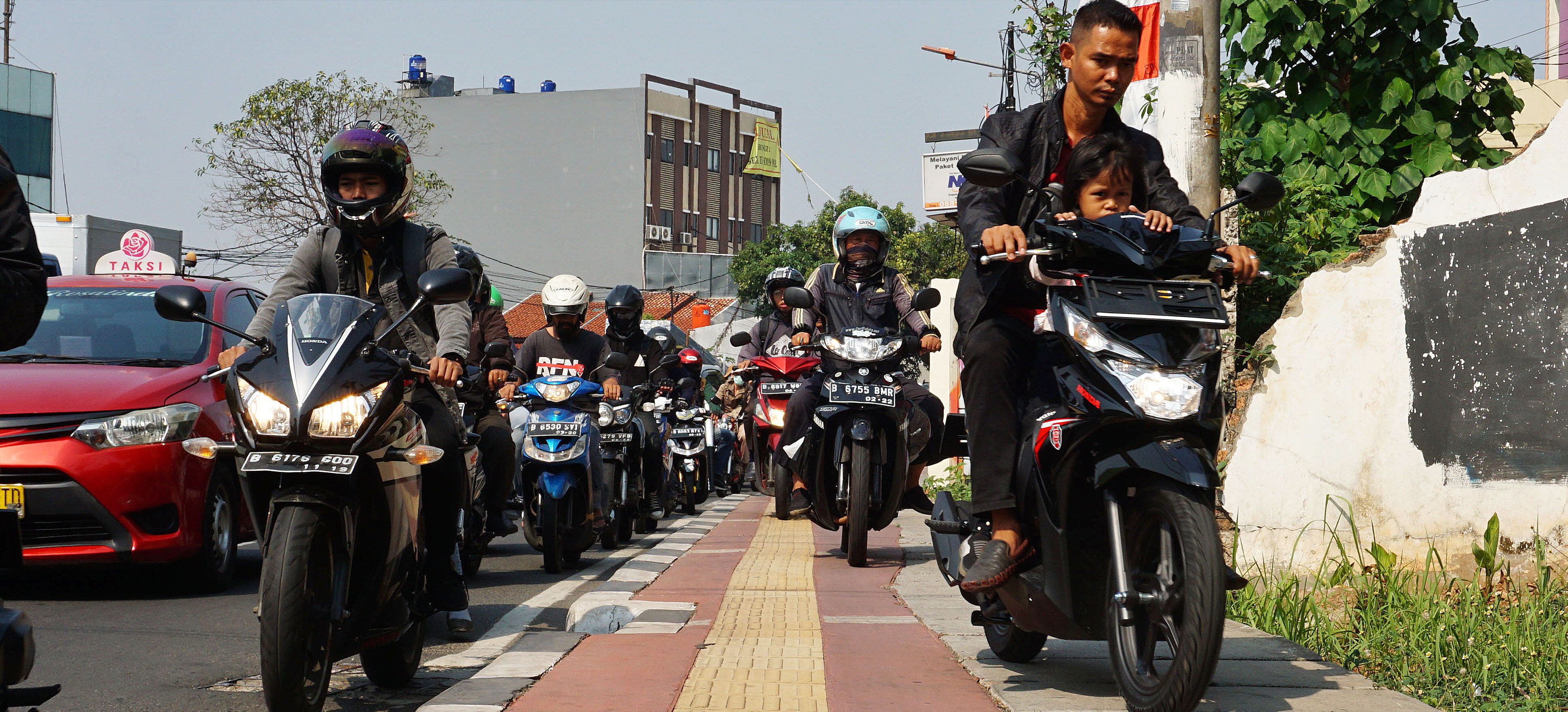 Pengendara sepeda motor melintas di atas trotoar pejalan kaki di Jalan Joglo Raya, Jakarta Barat, Kamis (24/10/2019).