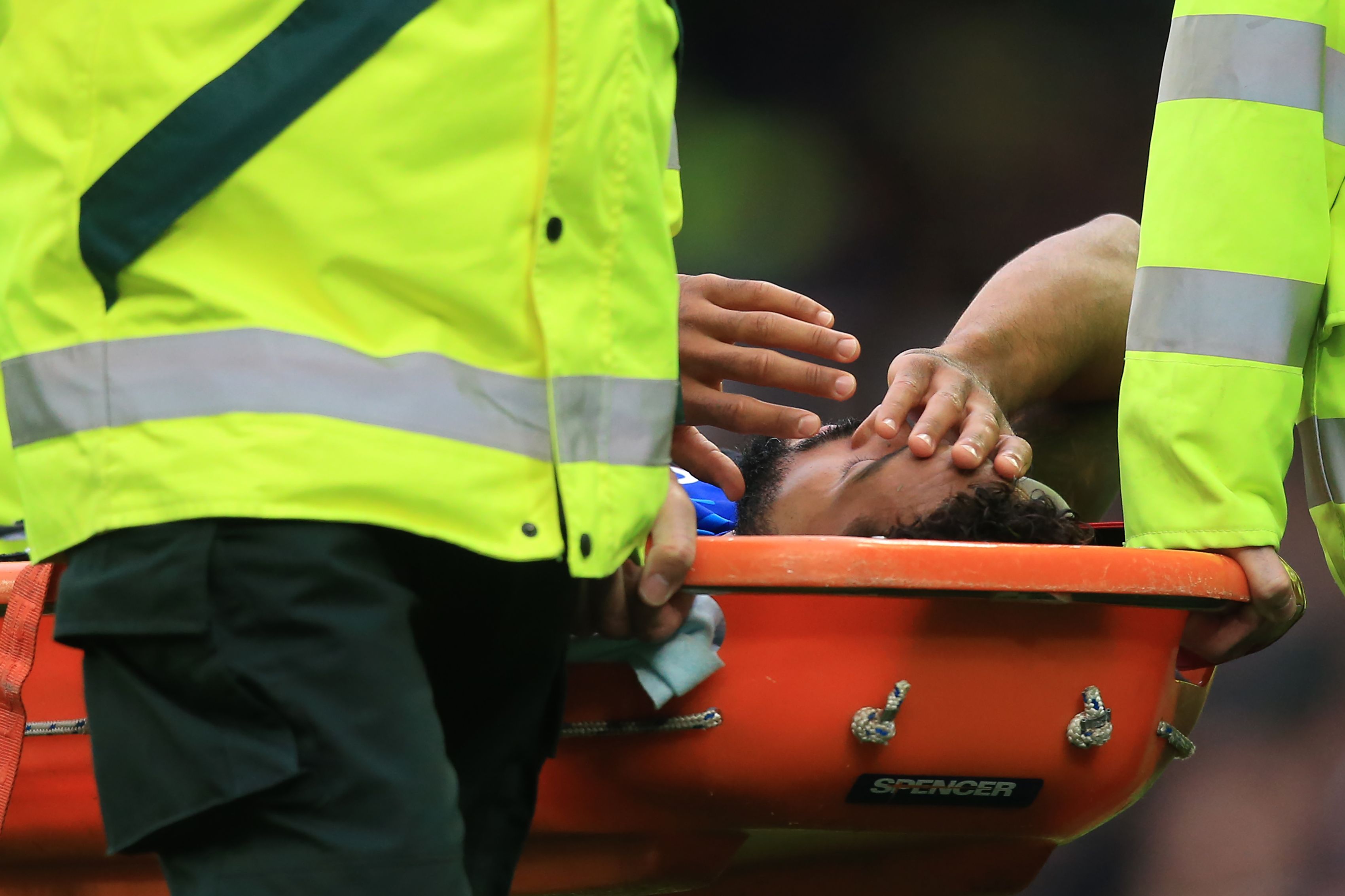 Theo Walcott ditandu meninggalkan lapangan usai mengalami cedera kepala dalam laga melawan Manchester City.