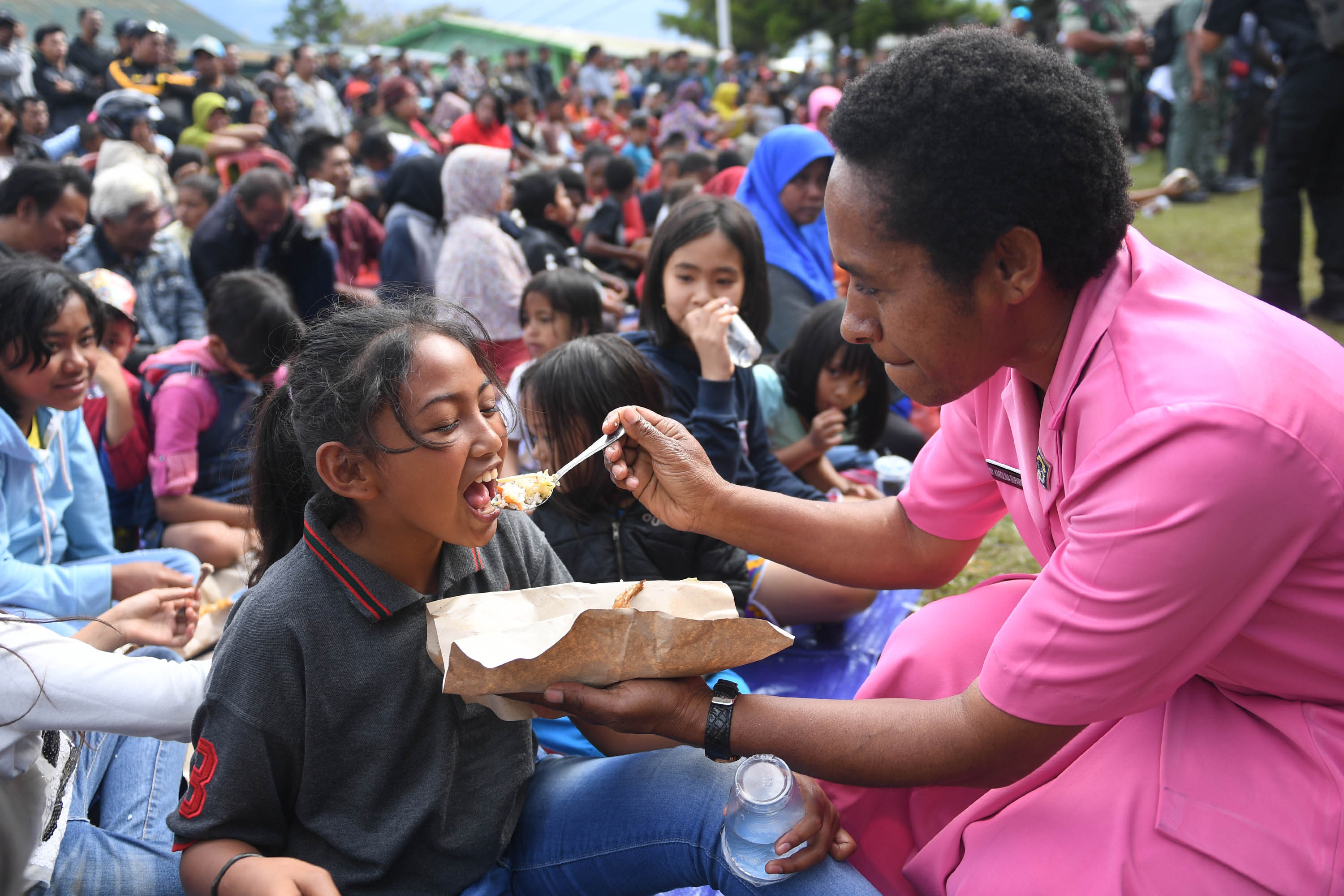  Ibu Bhayangkari menyuapi makanan pada bocah pengungsi di Posko pengungsian di Makodim 1702/Jayawijaya, Wamena, Papua, Selasa (8/10). 