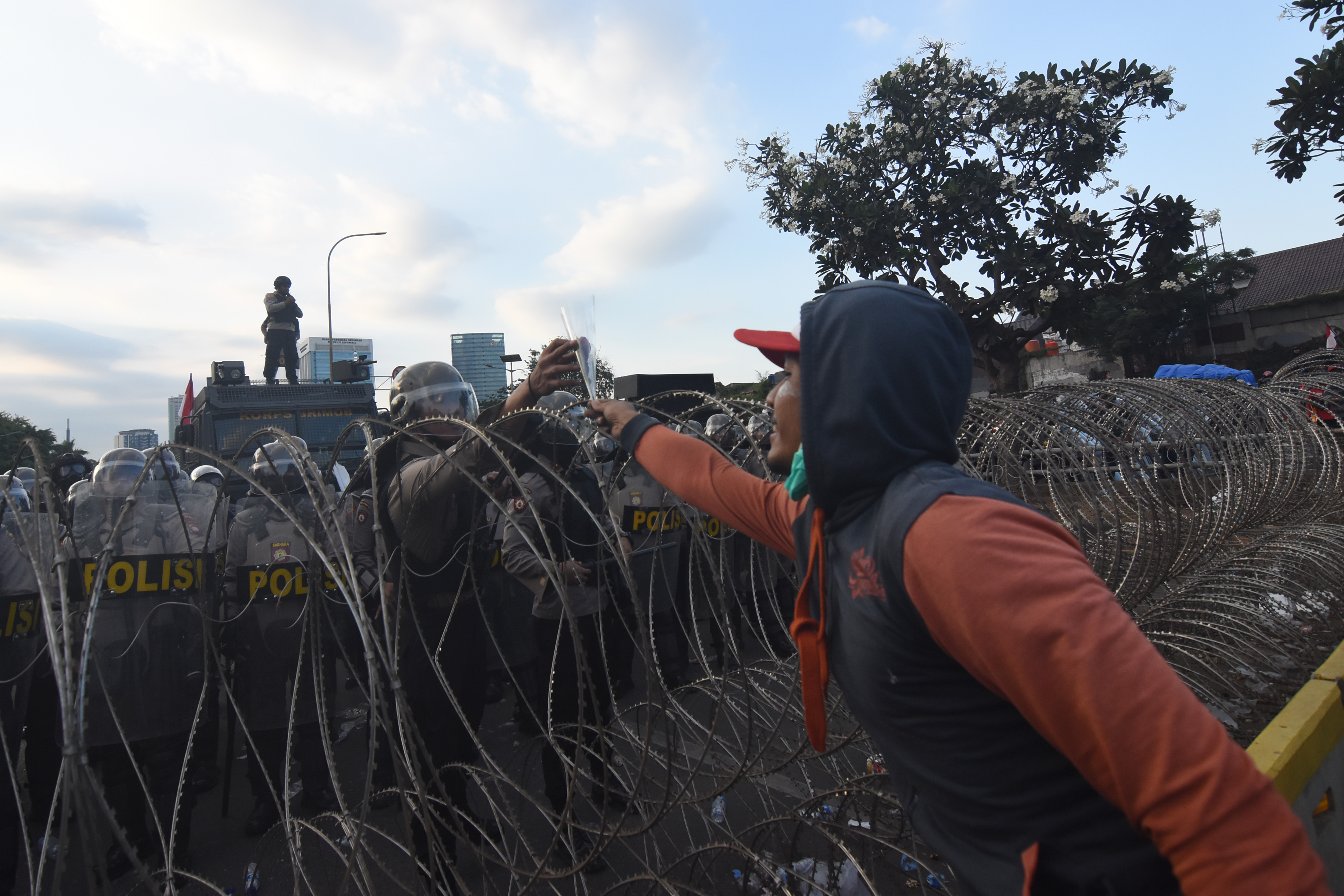 Pengunjuk rasa memberi bunga kepada polisi saat aksi unjuk rasa di depan Gedung DPR/MPR, Jakarta, Senin (30/9)