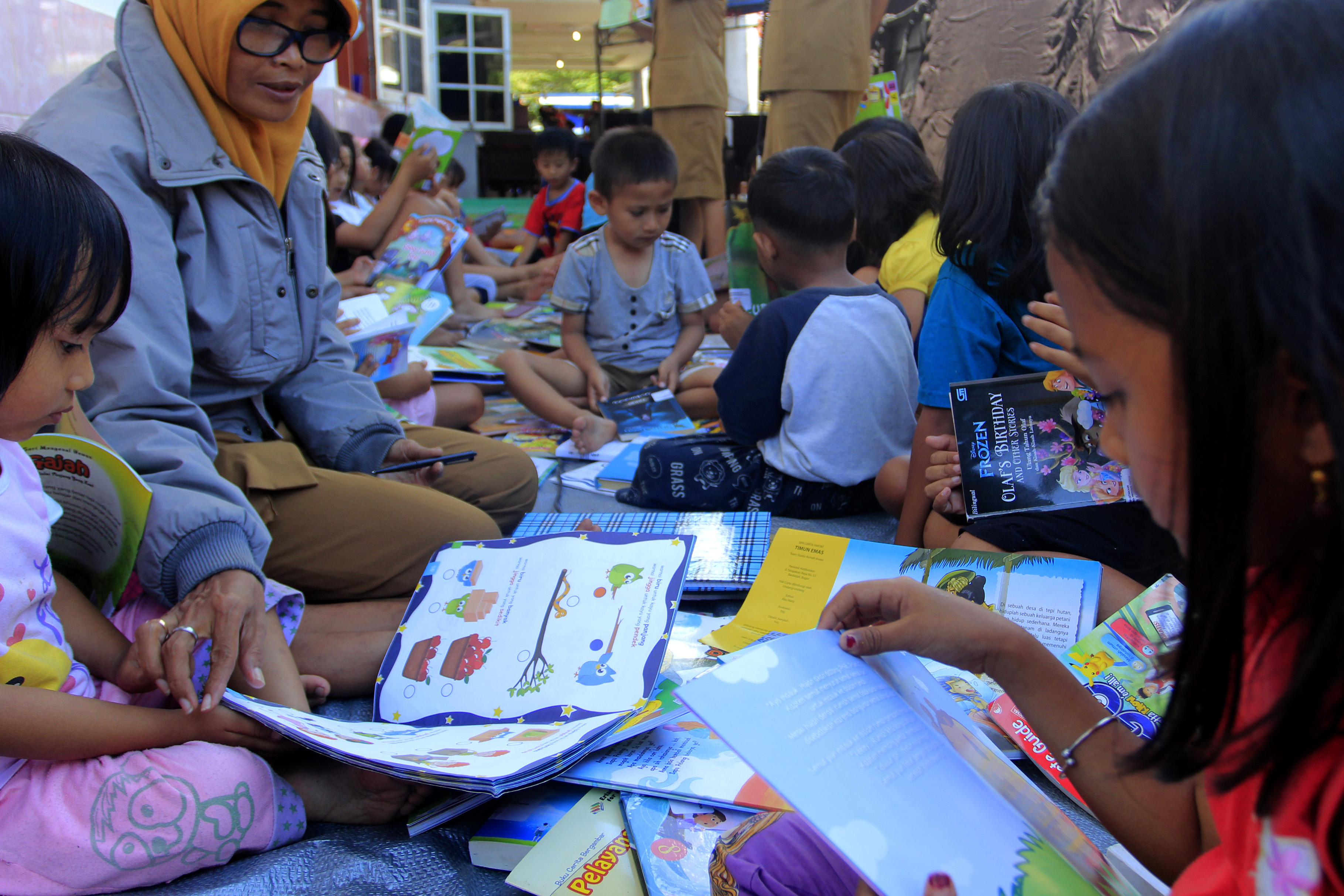 Sejumlah anak pengungsi Wamena membaca buku cerita di posko pengungsian Tongkonan, Kotaraja, Jayapura, Papua.