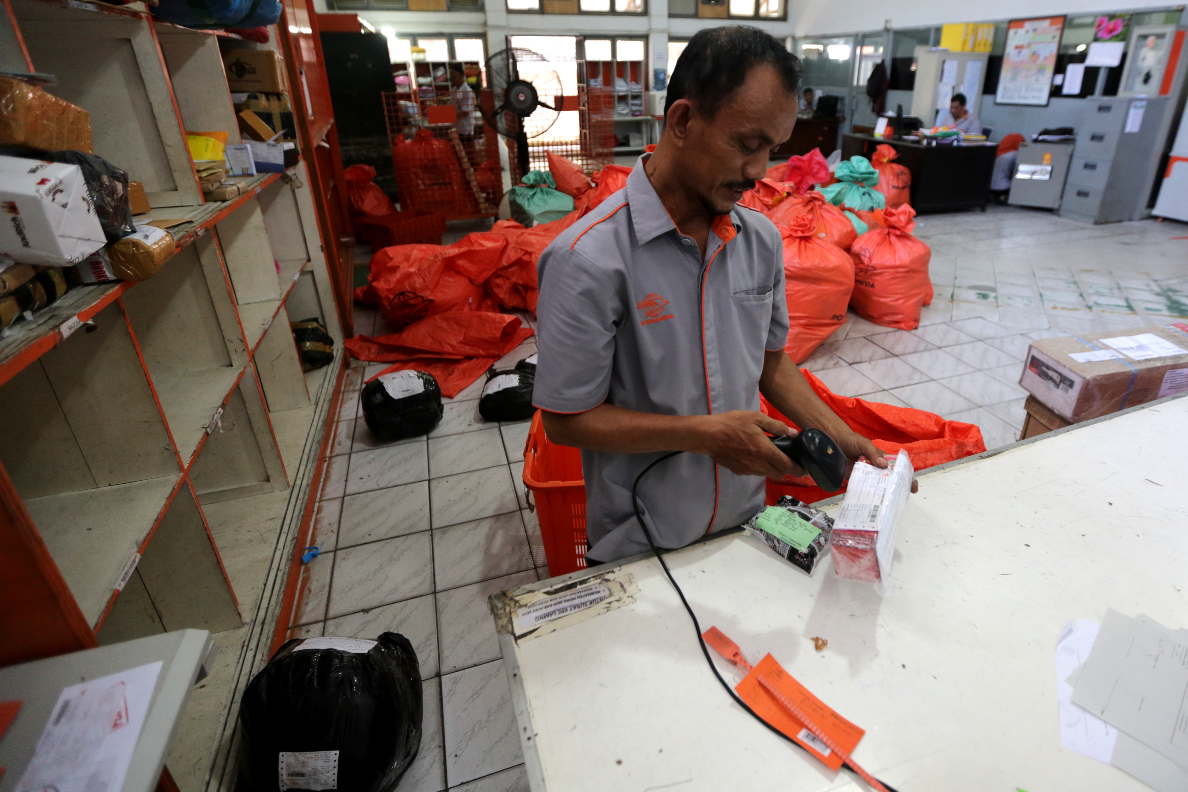 Petugas PT Pos Indonesia melakukan verifikasi barang yang akan dikirim dan diterima di Banda Aceh, Aceh, Senin (3/6/2019).