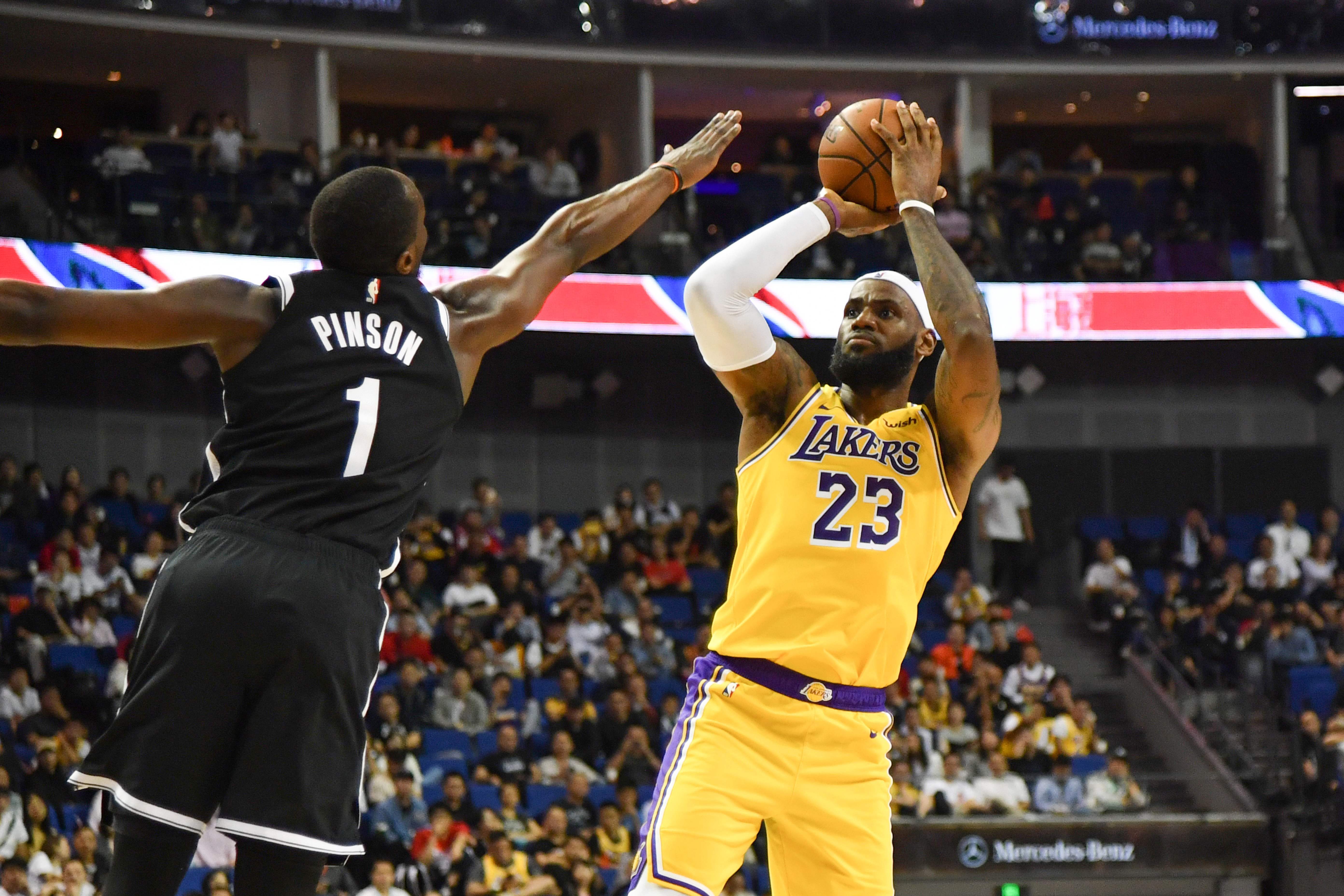 Bintang Los Angeles Lakers LeBron James (kanan) melepaskan tembakan dalam laga pramusim melawan Brooklyn Nets di Tiongkok
